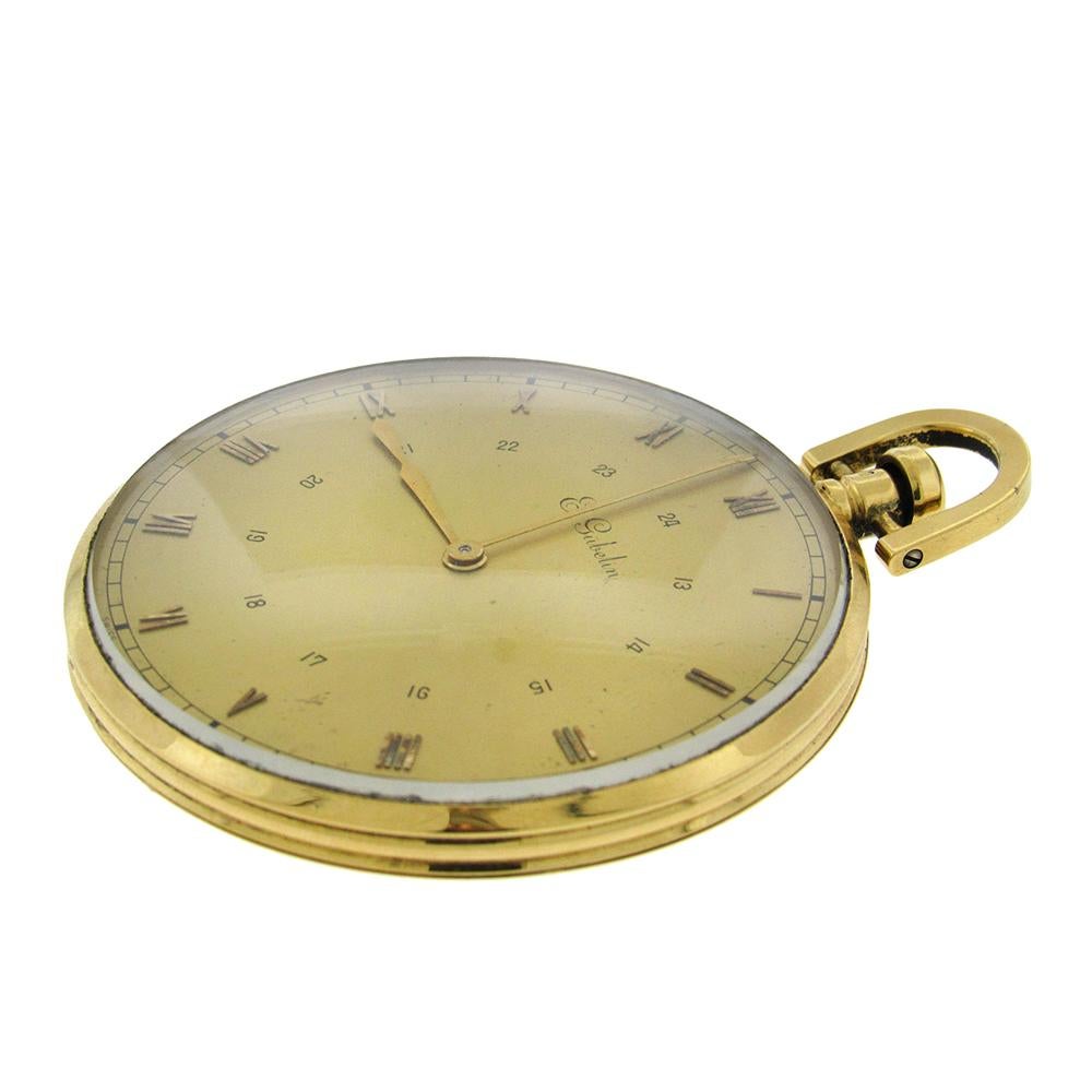 18K Gelbgold E.Gubelin Oversize 1930's 24 Stunden Taschenuhr ist eine sehr feine, dünne Taschenuhr mit offenem Gesicht. Das 56-mm-Gehäuse hat ein champagnerfarbenes Zifferblatt und  äußere aufgesetzte goldene Indexe mit römischen Ziffern und