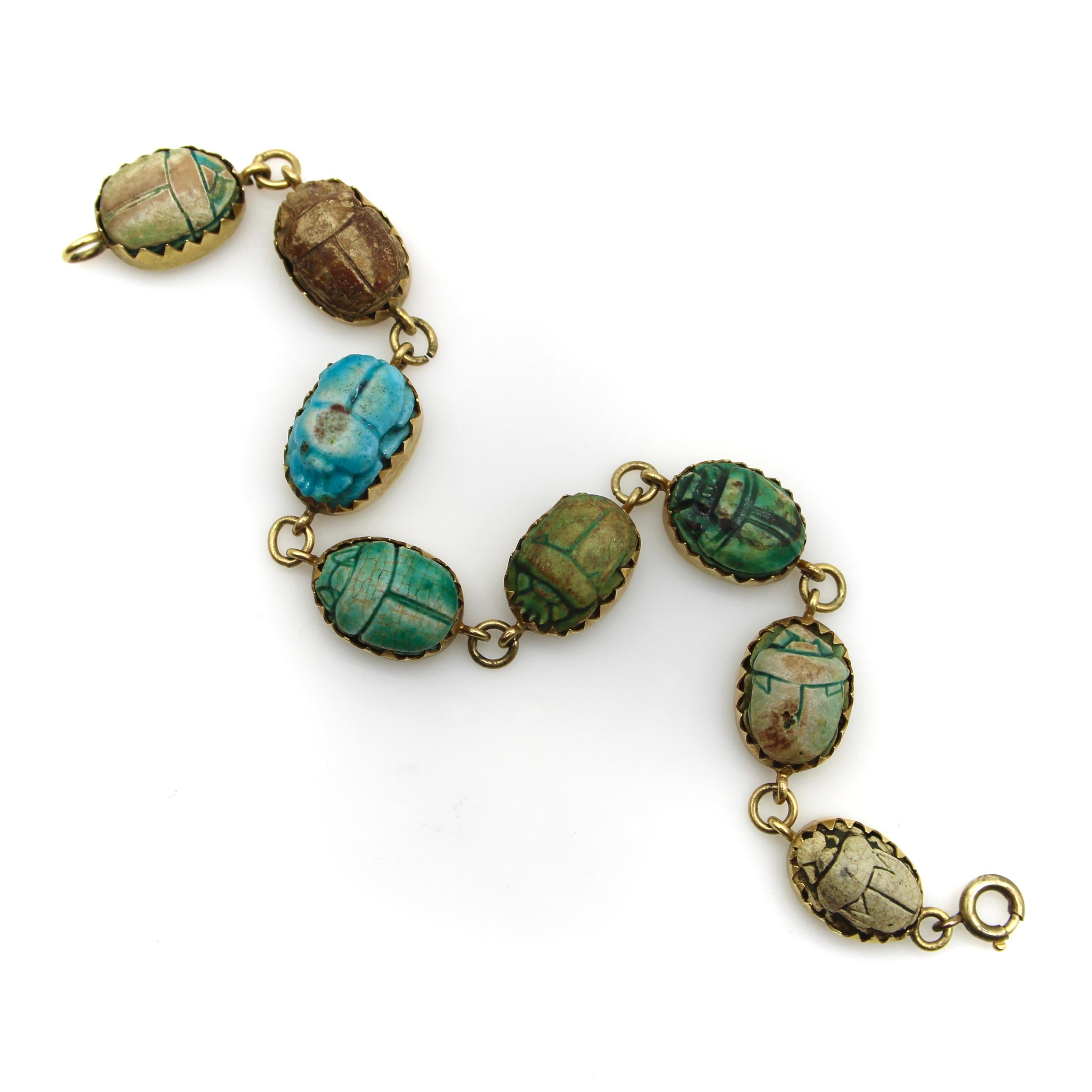 This 18k gold bracelet contains eight scarabs in various shades of blues, greens, and browns, each with a unique hieroglyphic. Made from clay, the scarab beads get their coloring when copper within the clay turns turquoise during the firing process;