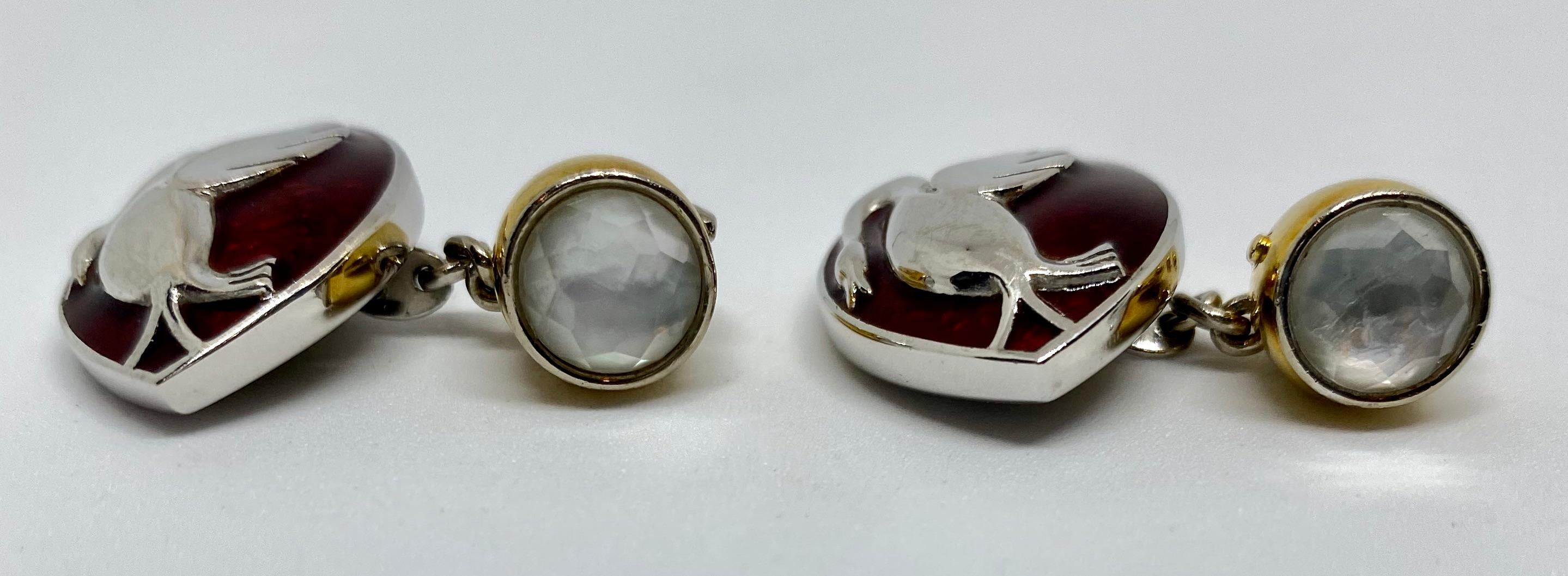 One-of-a-kind cufflinks custom-made in London for a collector of Packard Motor Cars. Rendered in solid 18K white and yellow gold, the lozenge-shaped faces bear the Packard cormorant emblem on a red enamel background. The backs, connected via 18K