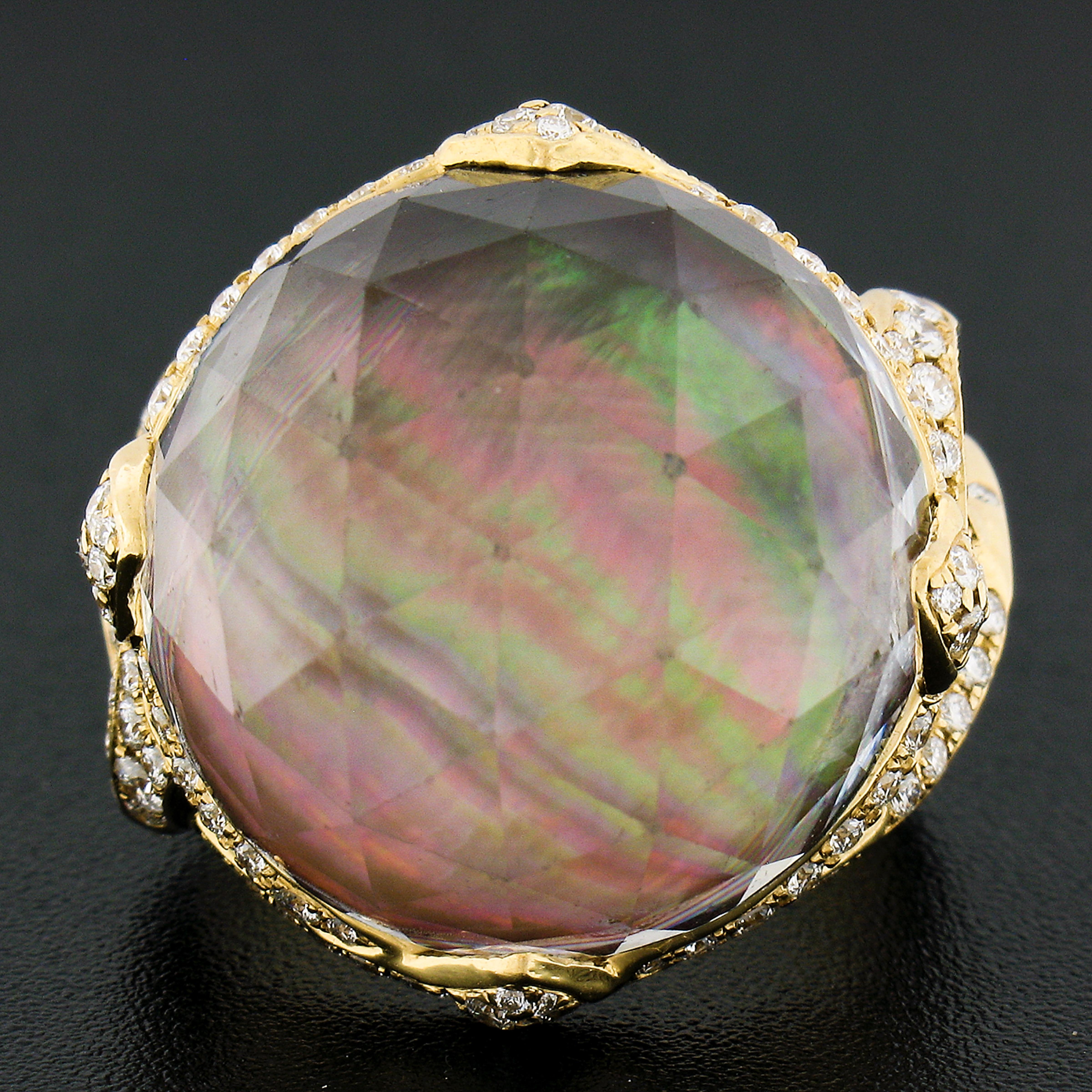 This gorgeous cocktail ring was crafted from solid 18k yellow gold. The ring features a large rock crystal stone that sits on a black mother of pearl disk giving it a great look & a beautiful play of colors. The crystal is a large round faceted cut.