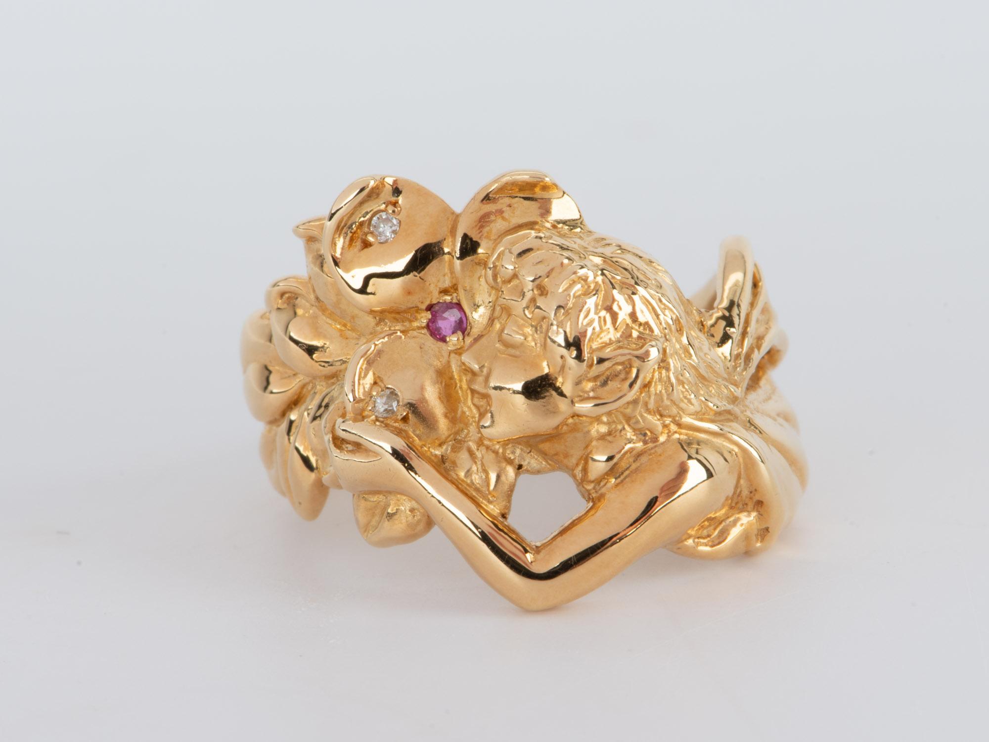   This stunning 18K gold ring is the perfect choice for any jewelry lover! With an Art Nouveau-inspired design, this elegant ring flourishes with a beautiful hair-flowing fairy and sprinkled diamonds and a single ruby. It's the perfect addition to