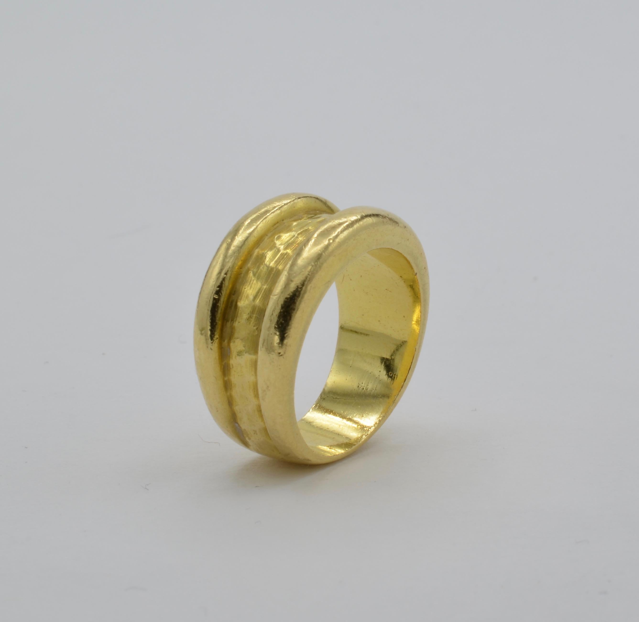 This substantial 18k gold ring has a beautiful hammered textured band in the middle creating an artistic and timeless look. Tapered in the back the ring blends together. The ring is a size 7 and can be sized to fit your finger.