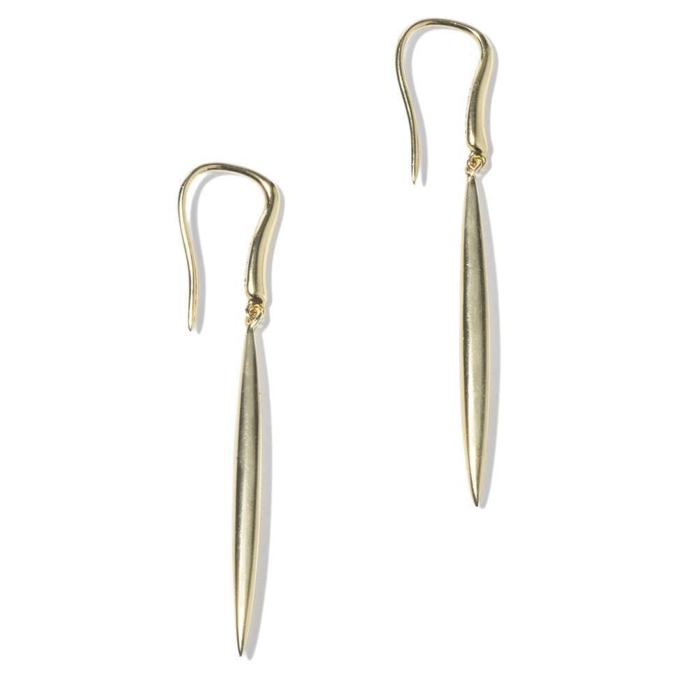 These earrings are slender and elongated, crafted from 18-karat gold with a smooth, glossy finish. They are part of the Tiffany & Co collection 