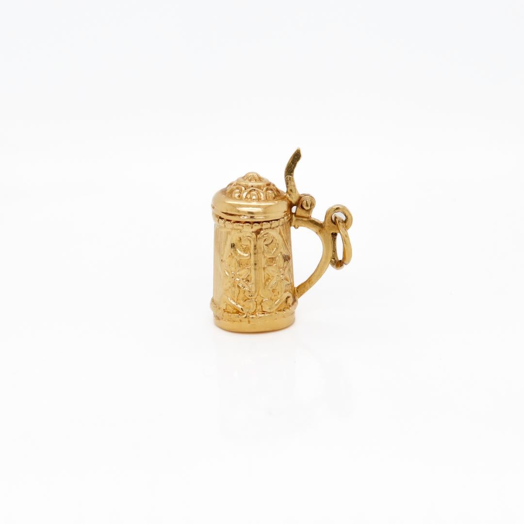 A fine gold charm.

In 18k gold.

In the form of an antique beer stein.

With a thumb lift, functional lid, and embossed decoration throughout.

Simply a wonderful charm!

Date:
20th Century

Overall Condition:
It is in overall good, as-pictured,