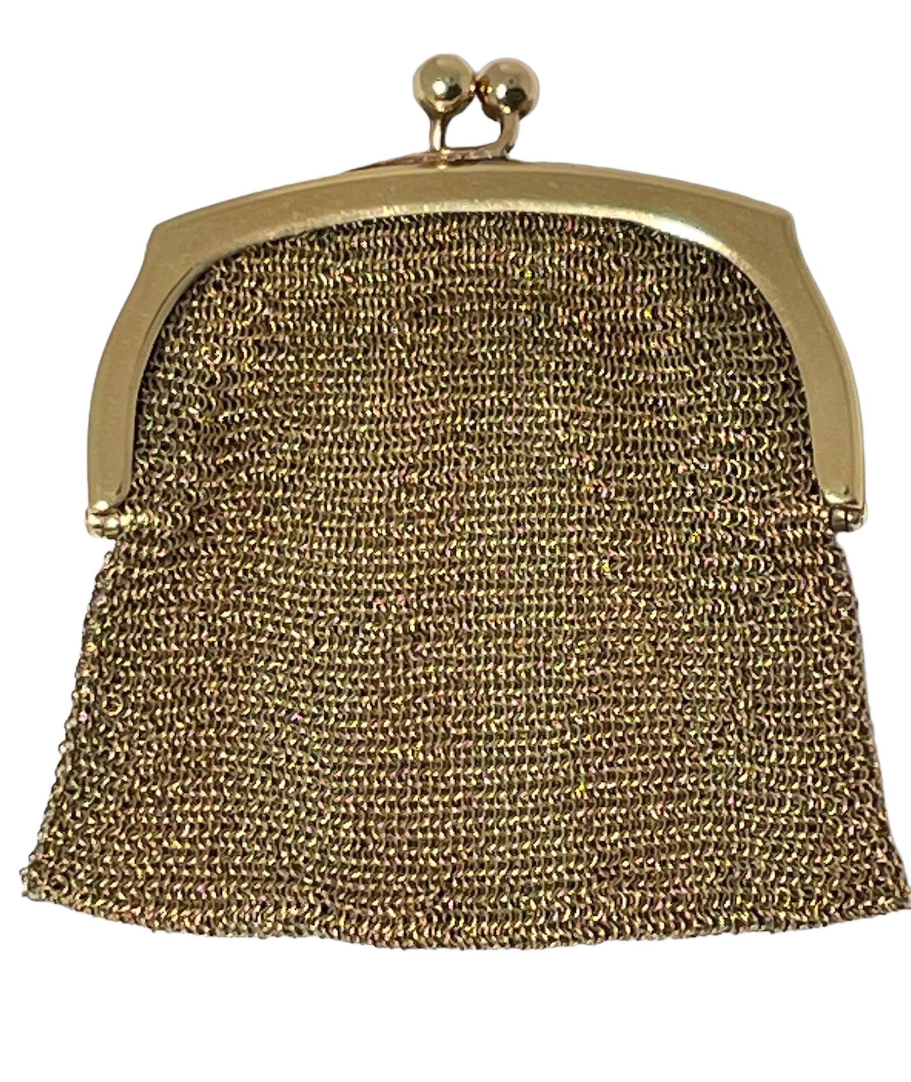 This is an 18kt gold flat mesh petite coin purse. It is made of multiples interwoven tiny rings. It closes and opens easily with a kiss-lock clasp. It is a shiny, flexible and easy to carry purse. Inside one of the gold upper border frame, it is