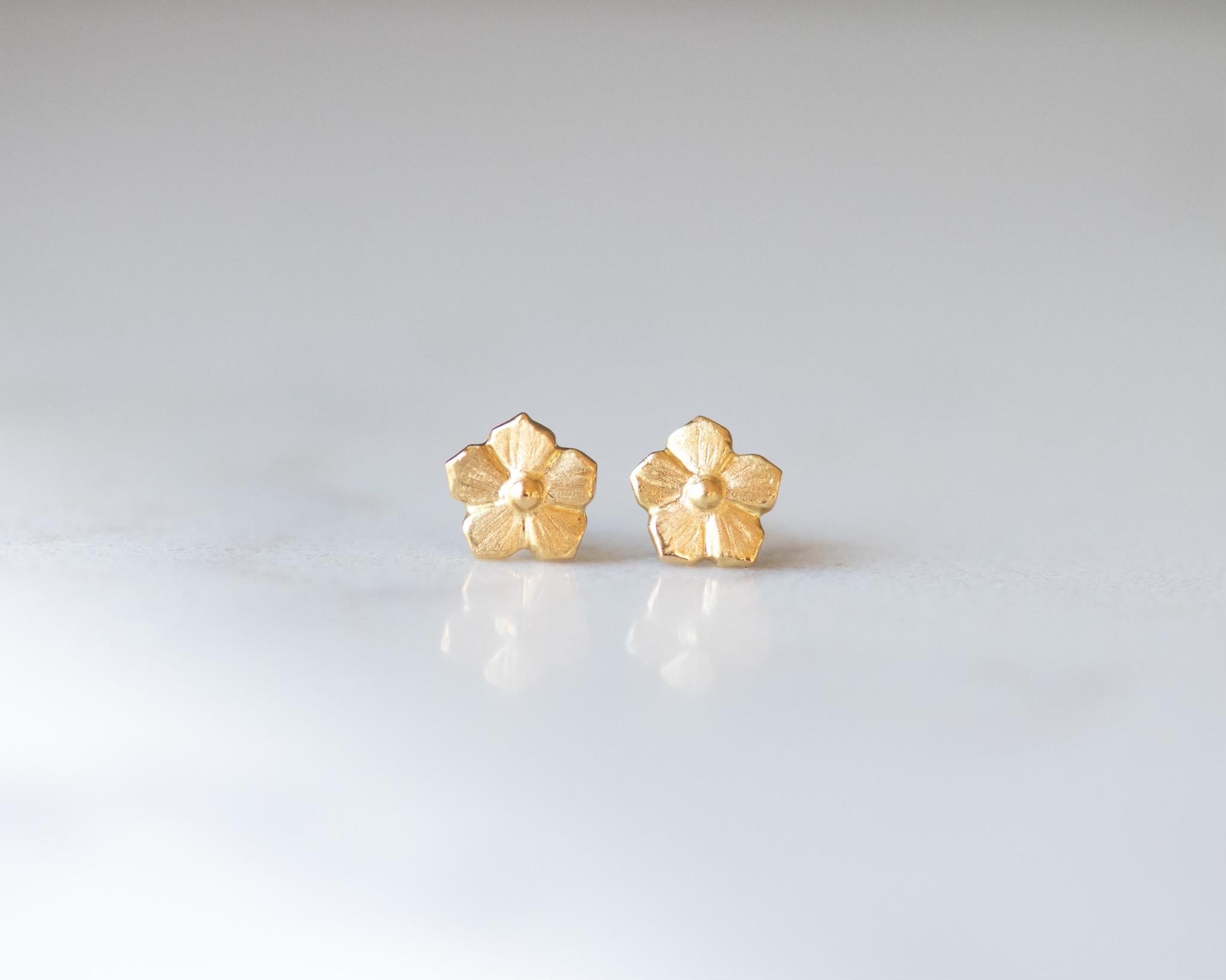 Classic 18K yellow gold forget me not stud earrings. A must have for any occasion or wear them year round. The perfect earring when wearing multiple earrings in one ear.  Jennifer hand carved these little 18K gold flower earrings. They have amazing