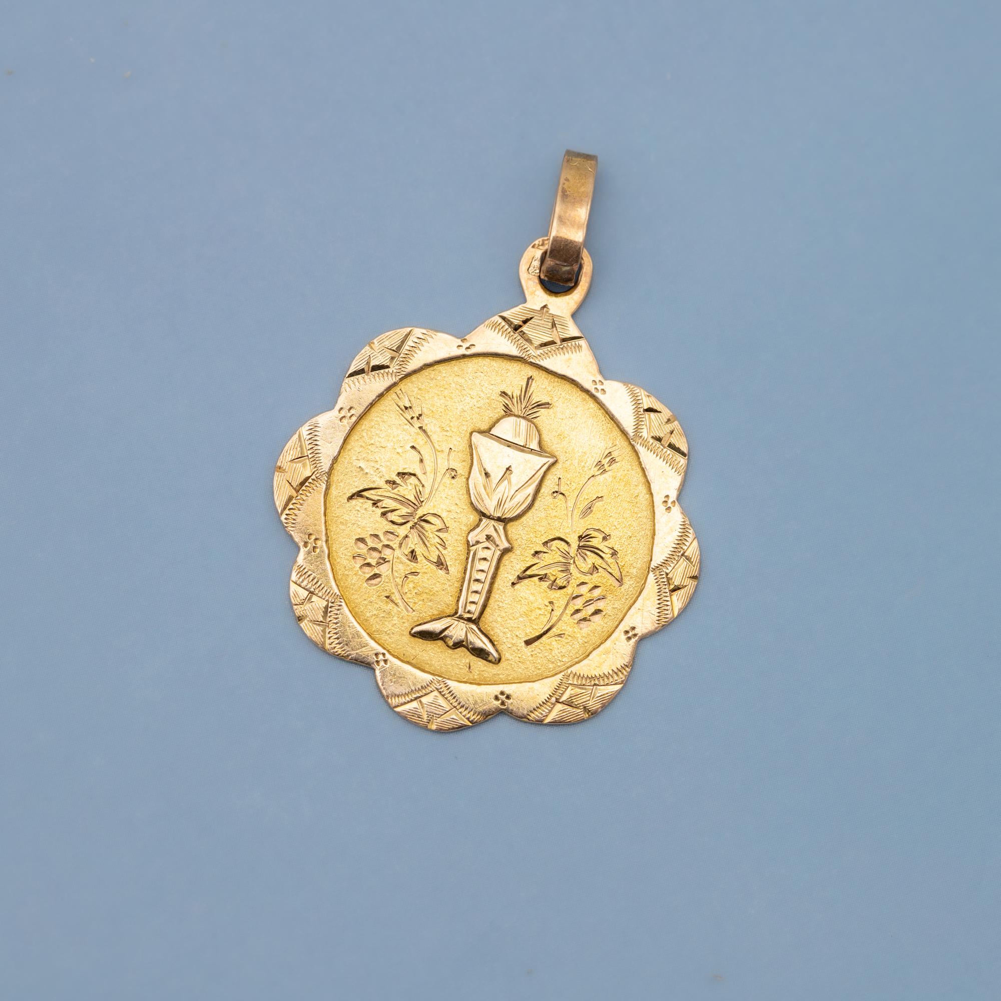We are delighted to introduce this lovely 18 karat pinkish yellow gold patina medal featuring a chalice, which is a cup often use for drinking during a religious ceremony. A host is sparkling above it. This well detailled chalice is flanked with a