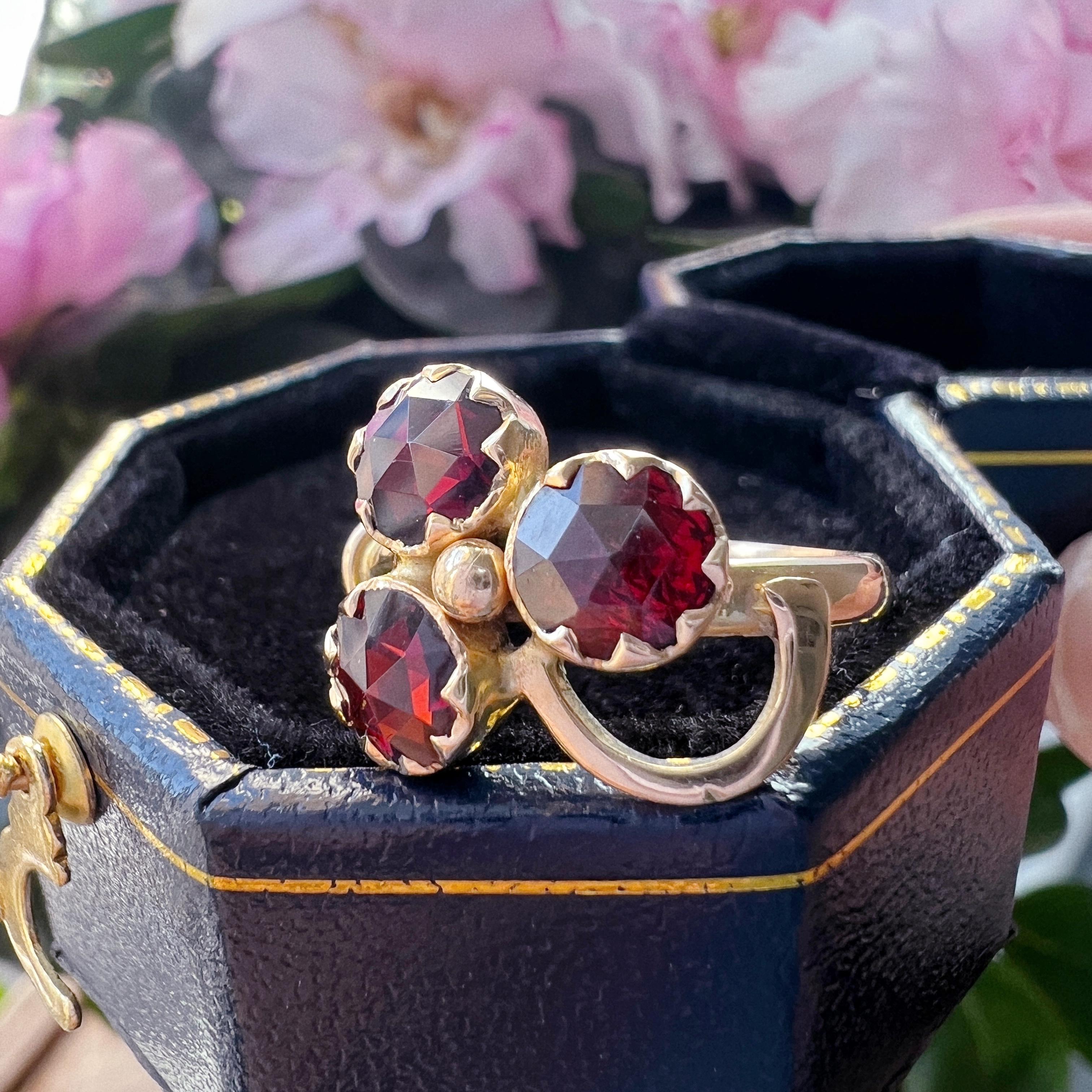 For sale a very beautiful 18K gold ring, featuring 3 French Catalan Perpignan garnets in their characteristic deep & fiery red color.

The ring has a lovely clover flower design, which is the symbol of good luck. The 3 garnets are all “rose-cut” and