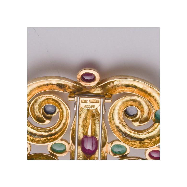 Vintage scrolled quatrefoil motif brooch, set with cabochon rubies, emeralds and sapphires, accented by smaller circular-cut diamonds. The brooch in hand-hammered 18k yellow gold and platinum.

Stamped 