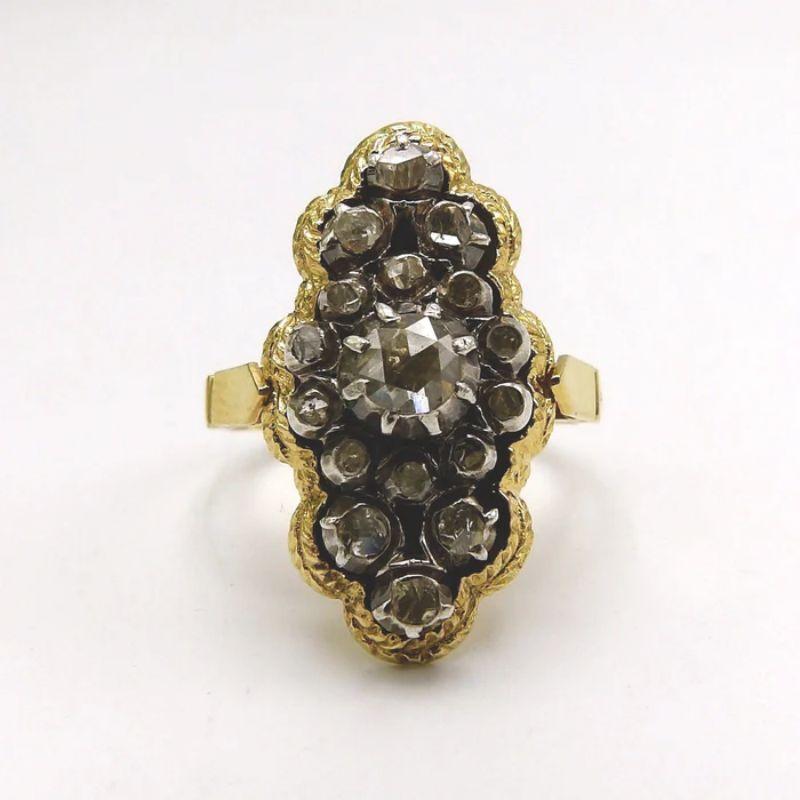 A beautiful diamond cluster ring, made of 17 rose cut diamonds against a foil back, with a collet setting of sterling silver in an 18 karat yellow gold ornate band and mount. This ring is remarkable piece of Georgian revival jewelry, made between