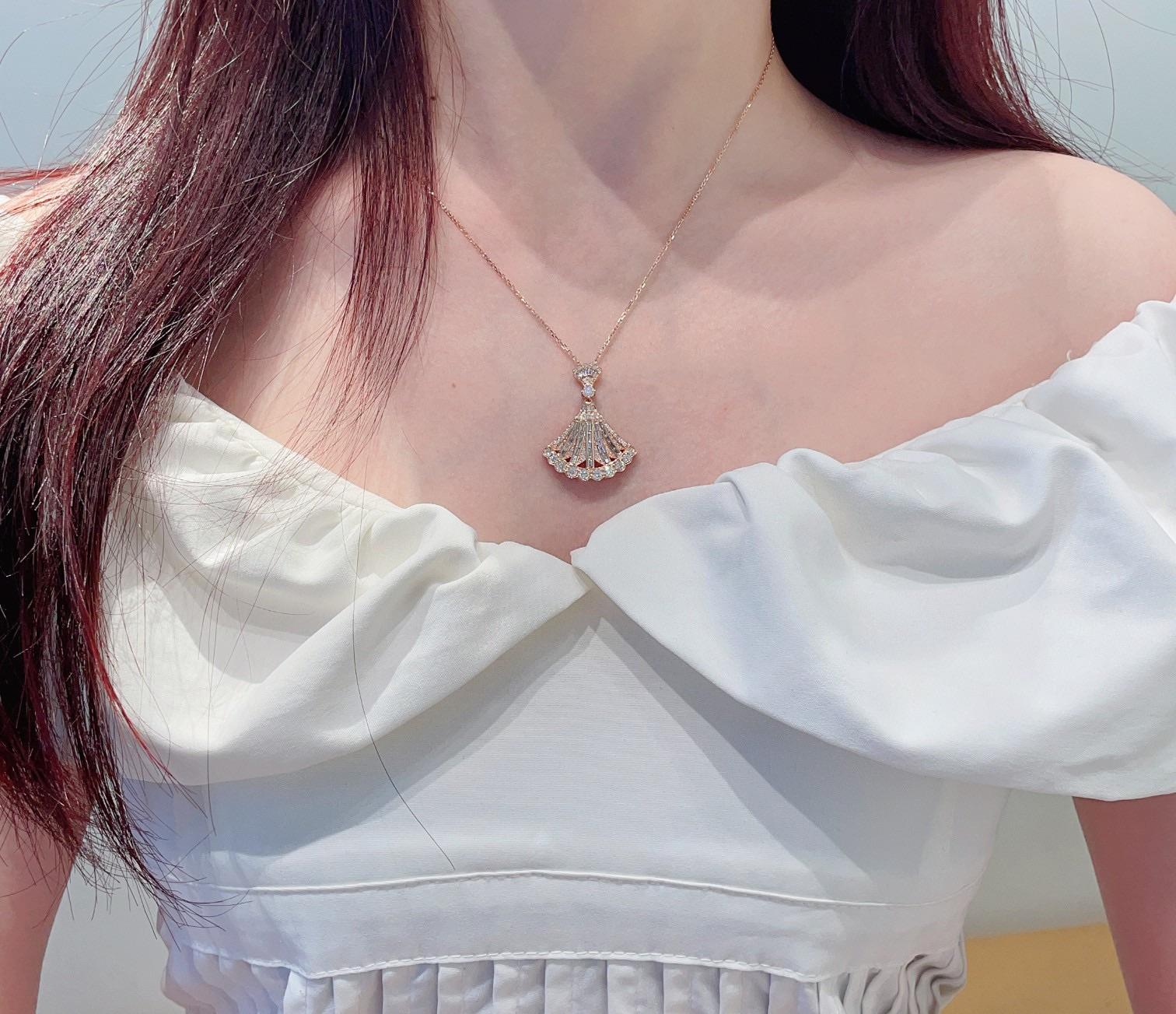 Bold and luxurious, this 18K gold necklace showcases a dramatic fan-shaped pendant adorned with a dazzling 0.38ct step-cut natural diamond at its center, framed by 1.01ct of radiant side stones. A statement piece of exceptional craftsmanship and