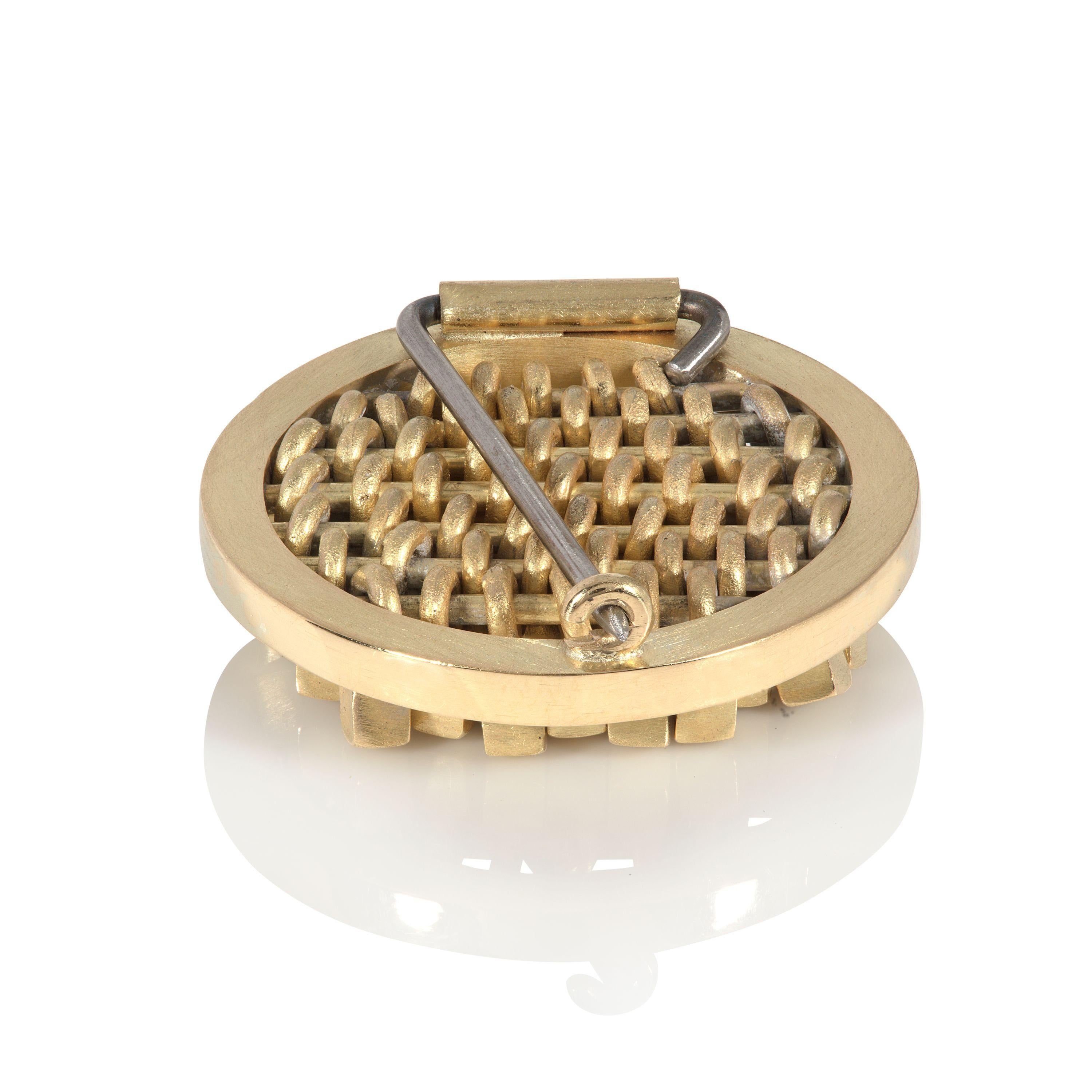 Cette broche élégante et frappante en or 18 carats est conçue et fabriquée par la bijoutière britannique Sarah Pulvertaft. Dans son cadre circulaire simple, la broche entière est composée de mini-cubes individuels. Ces cubes mobiles, qui captent