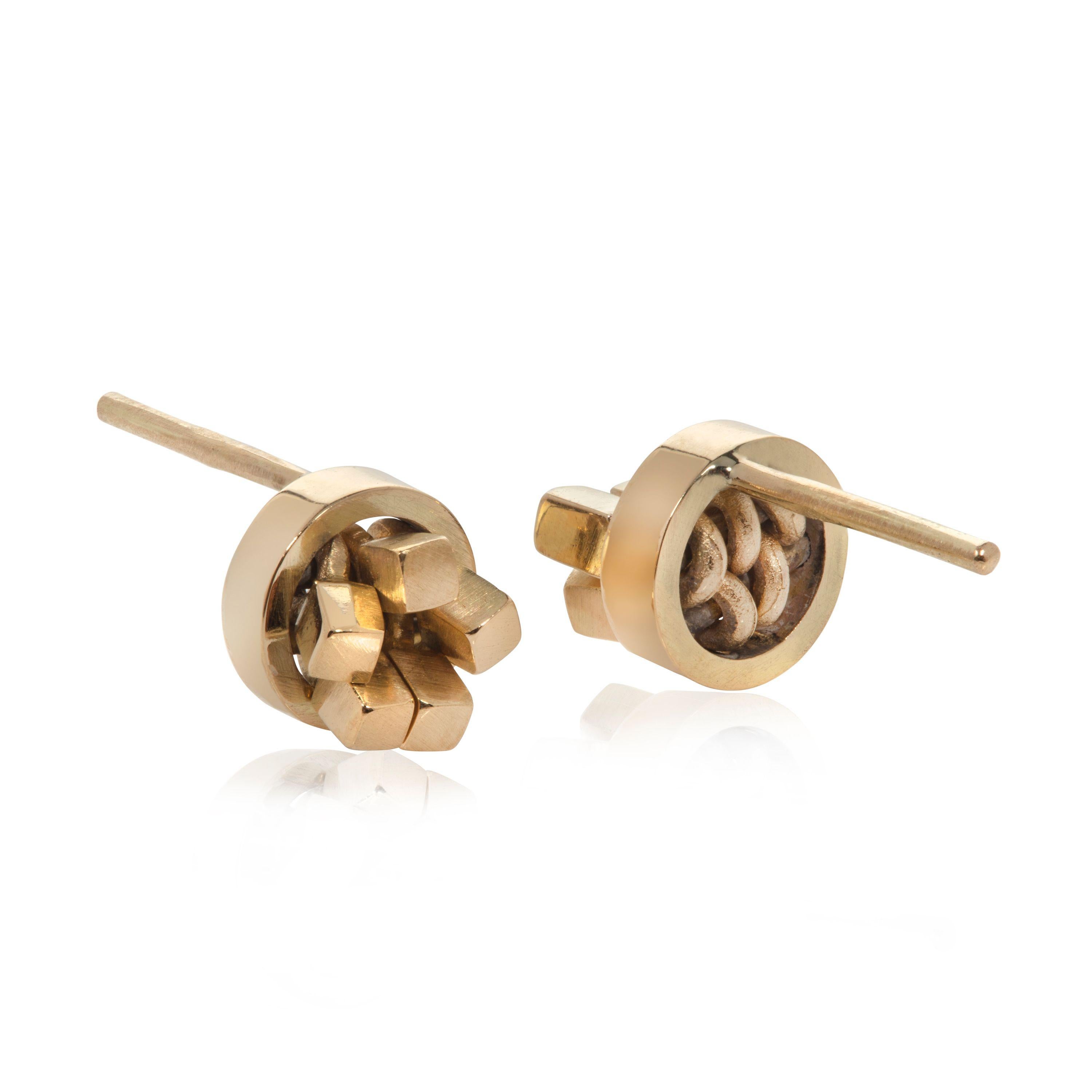These elegant, striking earrings in 18K gold are designed and made by UK jeweler Sarah Pulvertaft. Within its simple circle frame each earring is comprised of individual mini cubes. These moveable cubes, each capturing the reflection of light