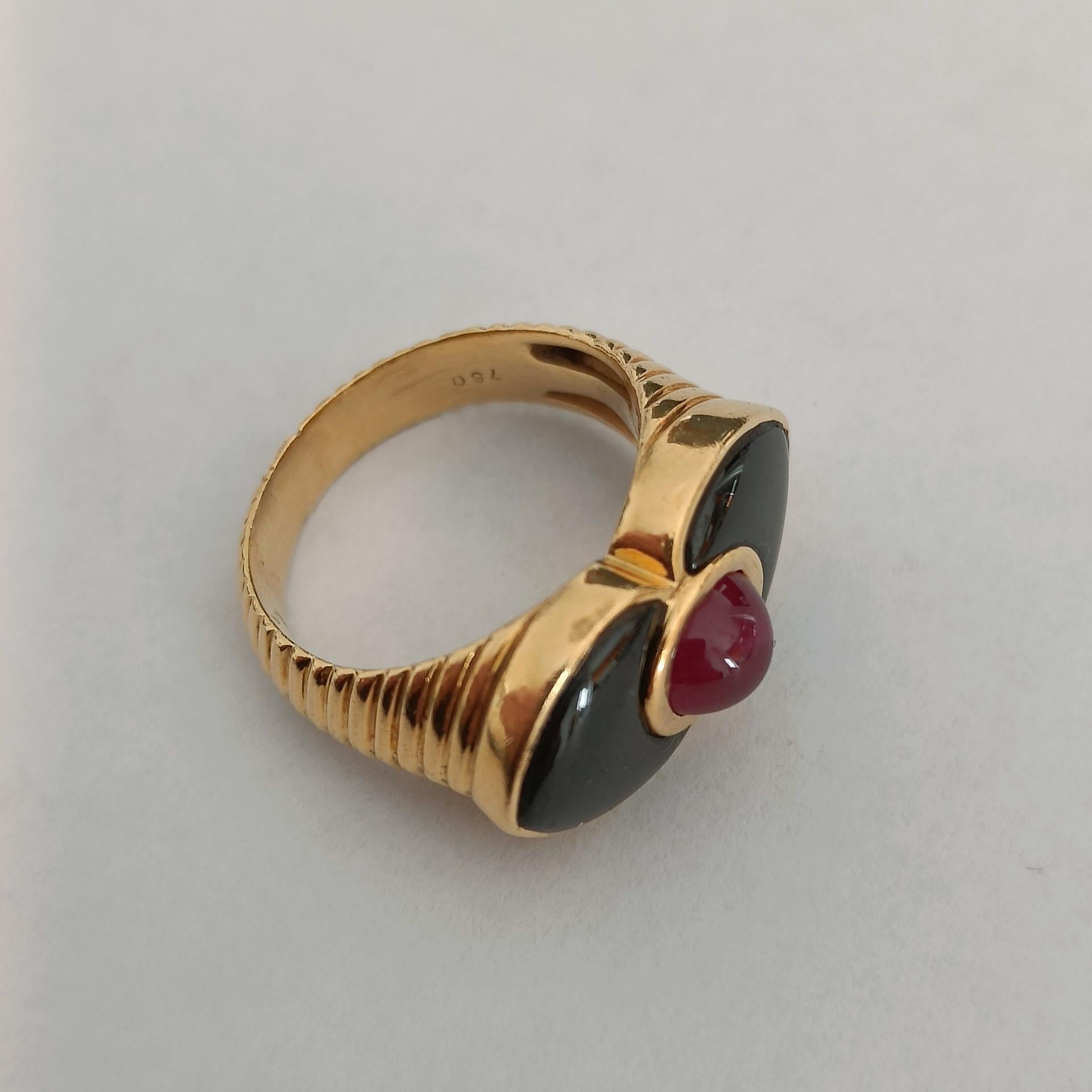 Ein Ring aus 18-karätigem Godronné-Gold mit einem Rubin-Cabochon, der von zwei spitz zulaufenden Onyx-Platten umrahmt ist. Schöne Blumenkomposition. Gestempelt 750.

Größe: FR 50 - US 5 (ca.)
Gewicht 8,10 Gramm

Sehr guter Zustand