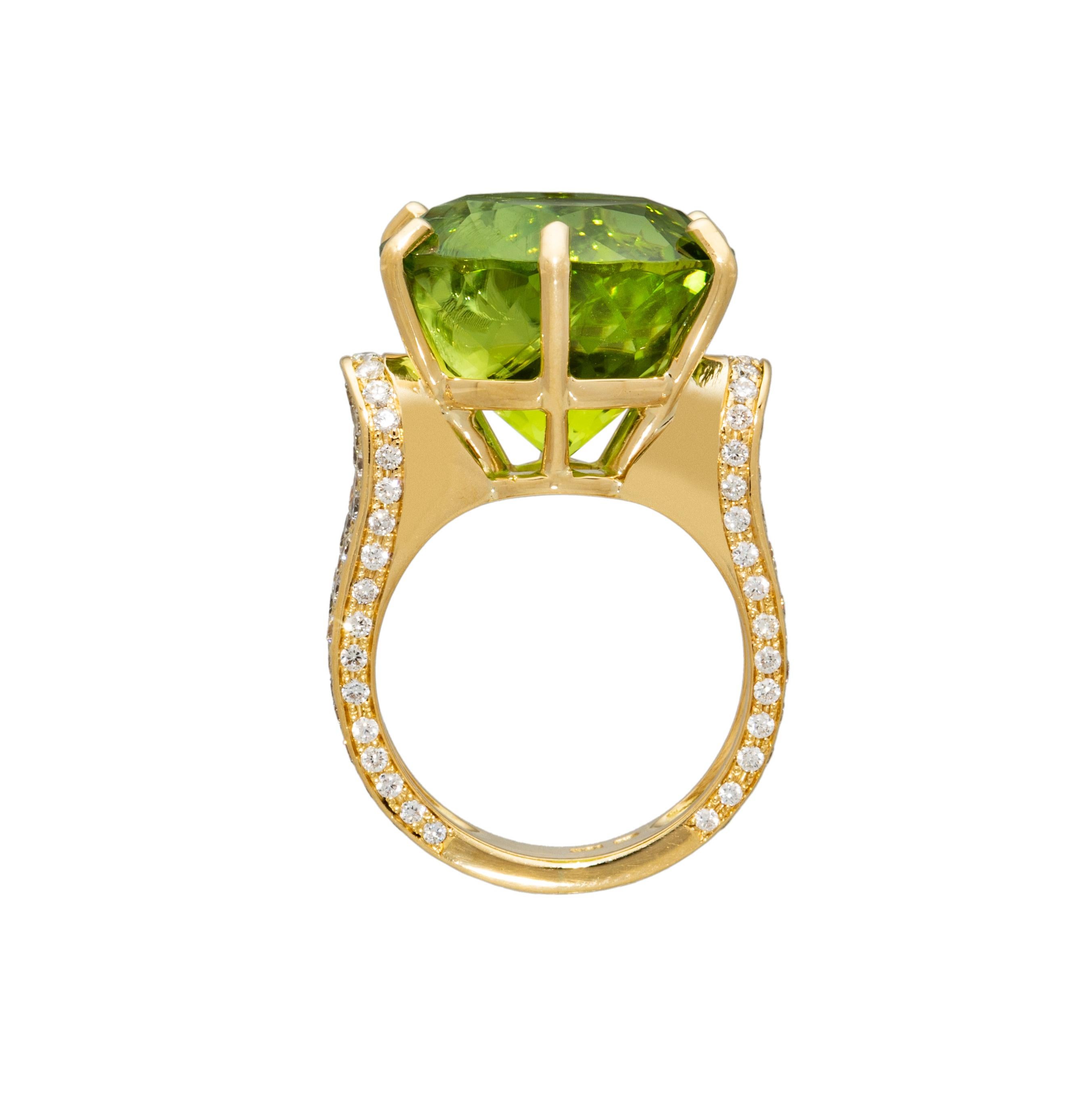 This magnificently bright green peridot ring in 18k yellow gold is an artistic wonder. The large peridot stone, cradled in a six-prong setting, is accentuated with pave-set diamonds down the sides in a cascading wall of brilliance. This trendy ring