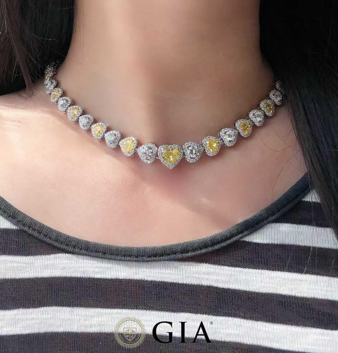 Realizzata in lussuoso oro massiccio 18 carati, questa collana mozzafiato ha come fulcro un raro diamante giallo a forma di cuore da 10,00 carati certificato GIA. Incorniciato da 9,90 carati di diamanti bianchi brillanti, questo design spettacolare
