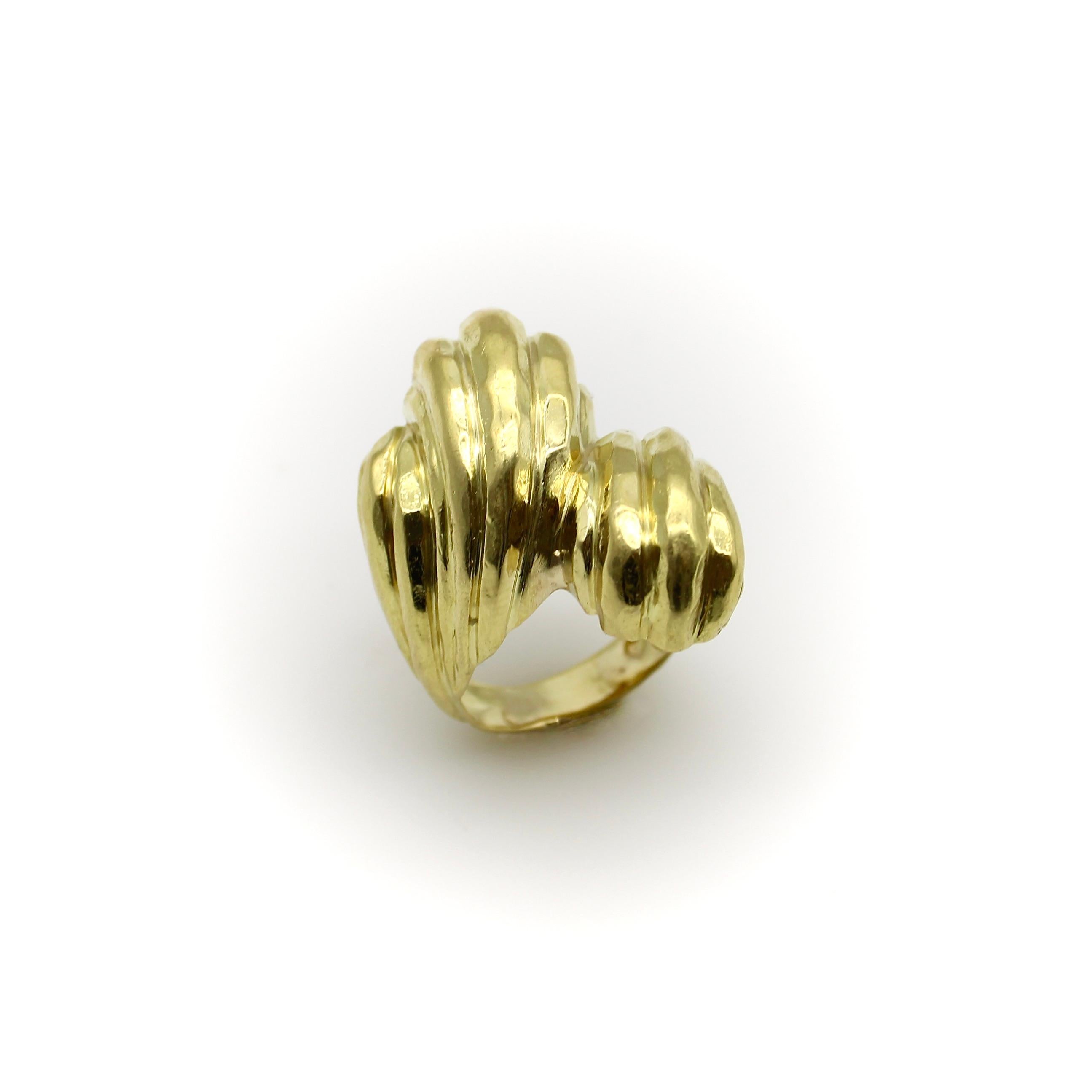This 18k gold ring is big and bold—a classic Henry Dunay design that has great presence on the hand. The ring is sculptural, with a hand-hammered finish that accentuates the large faceted planes of gold that reflect the light for a mesmerizing