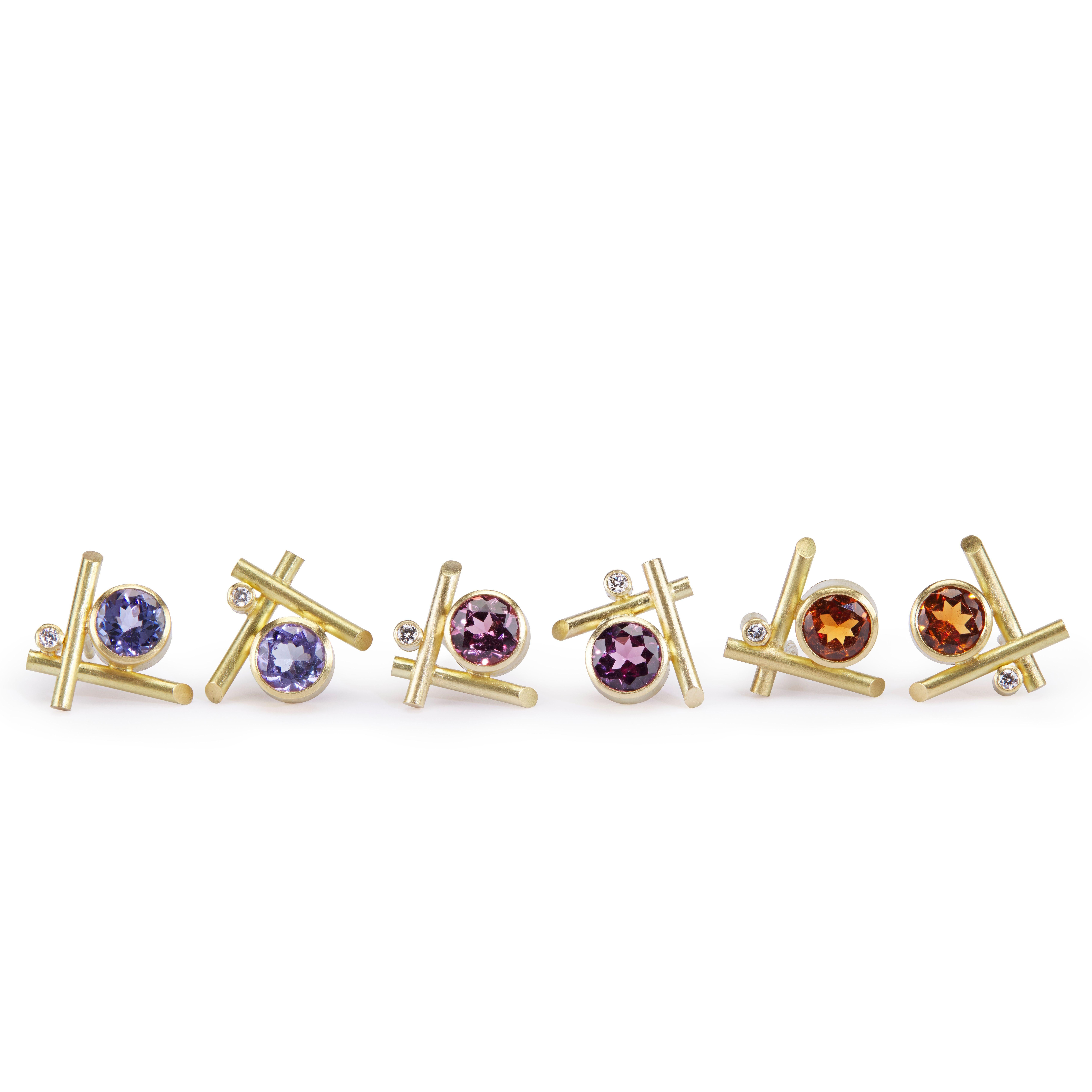 These very contemporary 18K gold stud pierced earrings feature a hessonite garnet accented by white diamonds. The garnet is a 5mm round. 
These earrings are designed and made by London jeweler, Lucy Martin. Lucy creates art jewelry with a unique