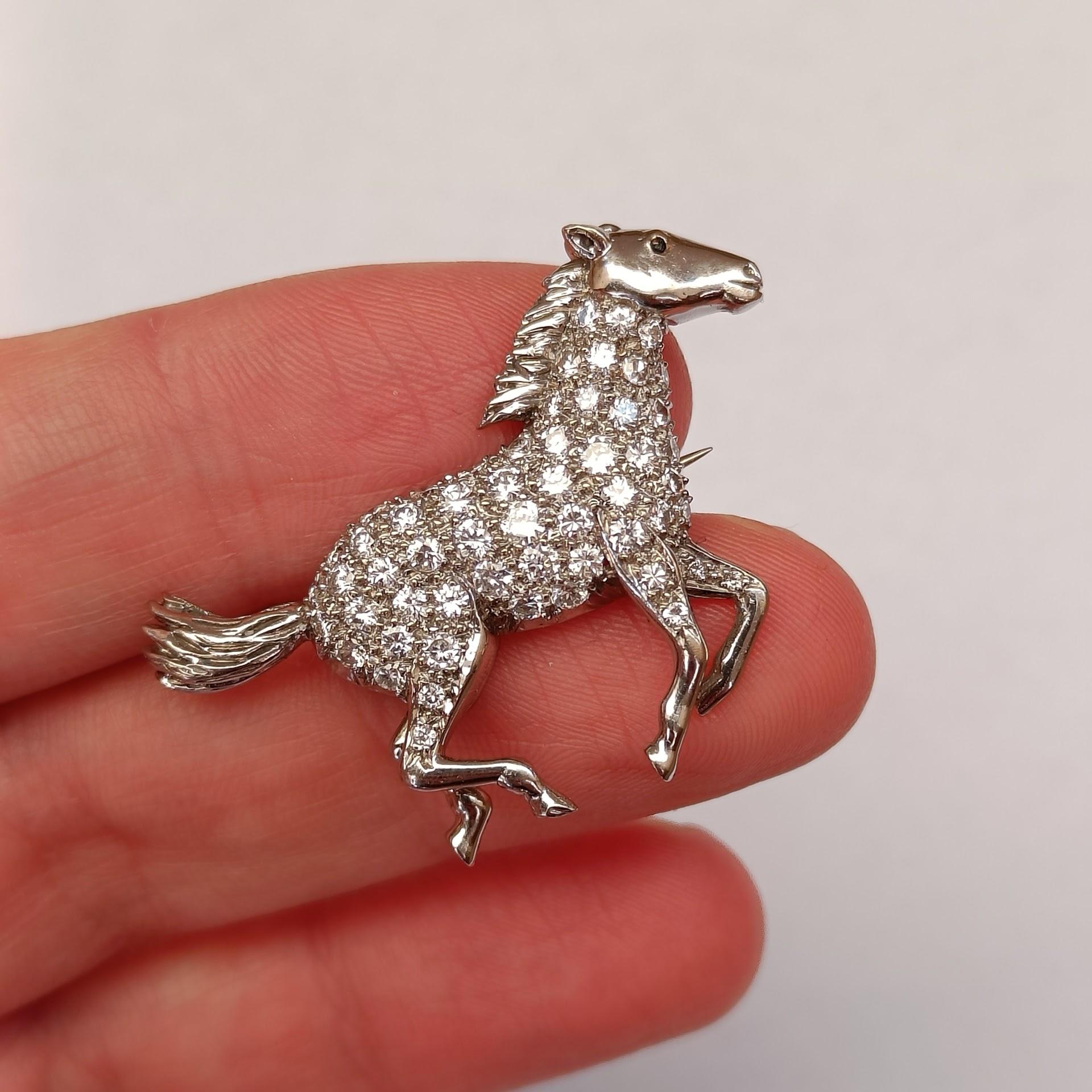 An 18k white gold brooch depicting a running horse, with diamond pave all over the body. Made by E. Wolfe & Co, London. Stamped EW & Co and 750.

Good condition, diamonds are of good quality, averaging VS-SI, I-L approximately, various