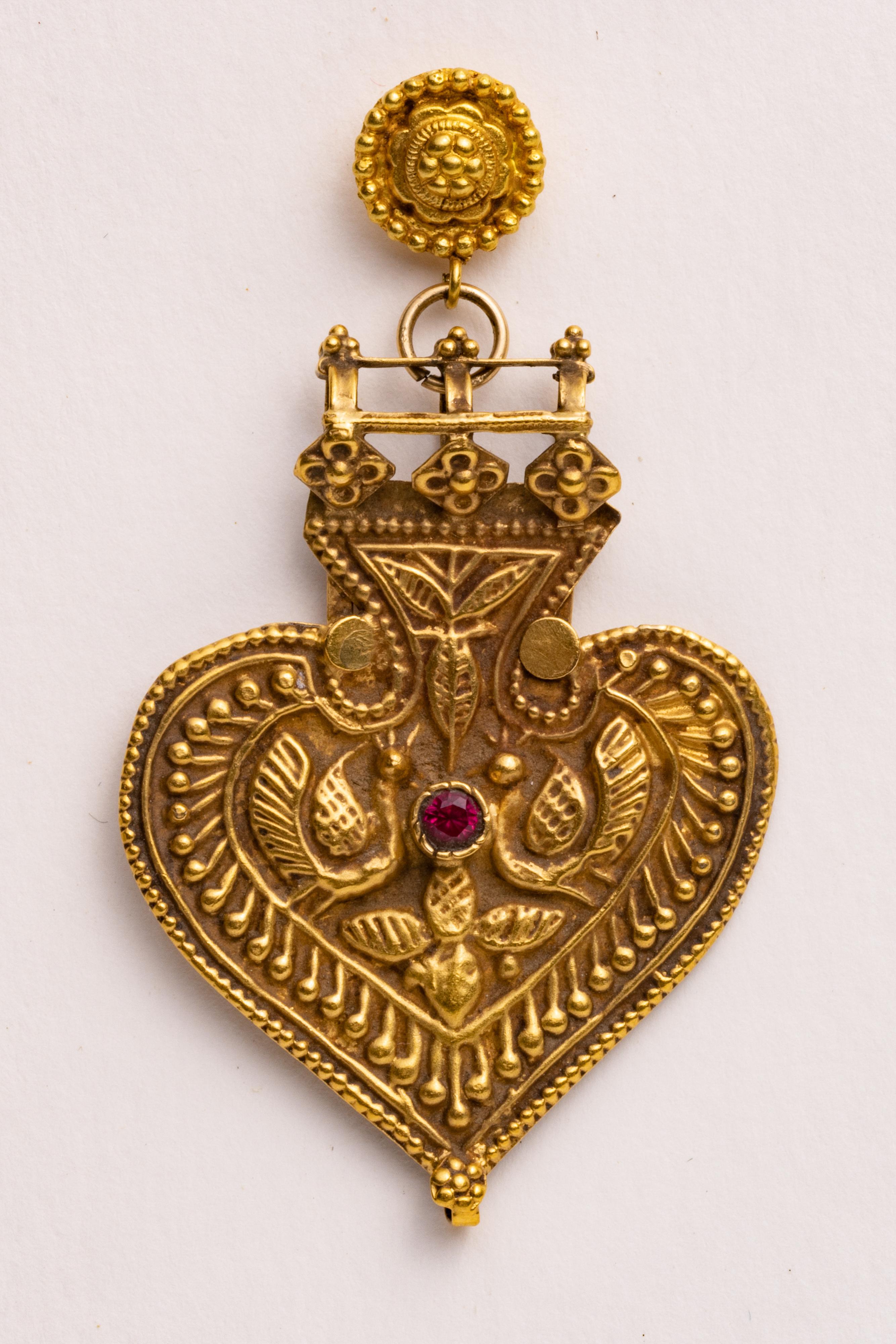 These are extraordinary Indian pendants converted to earrings.  If you look closely, these are not an exact pair.  They share the spade-shape and beautiful hand-tooled and 
 granulation workmanship, while one features a ruby center and the other an
