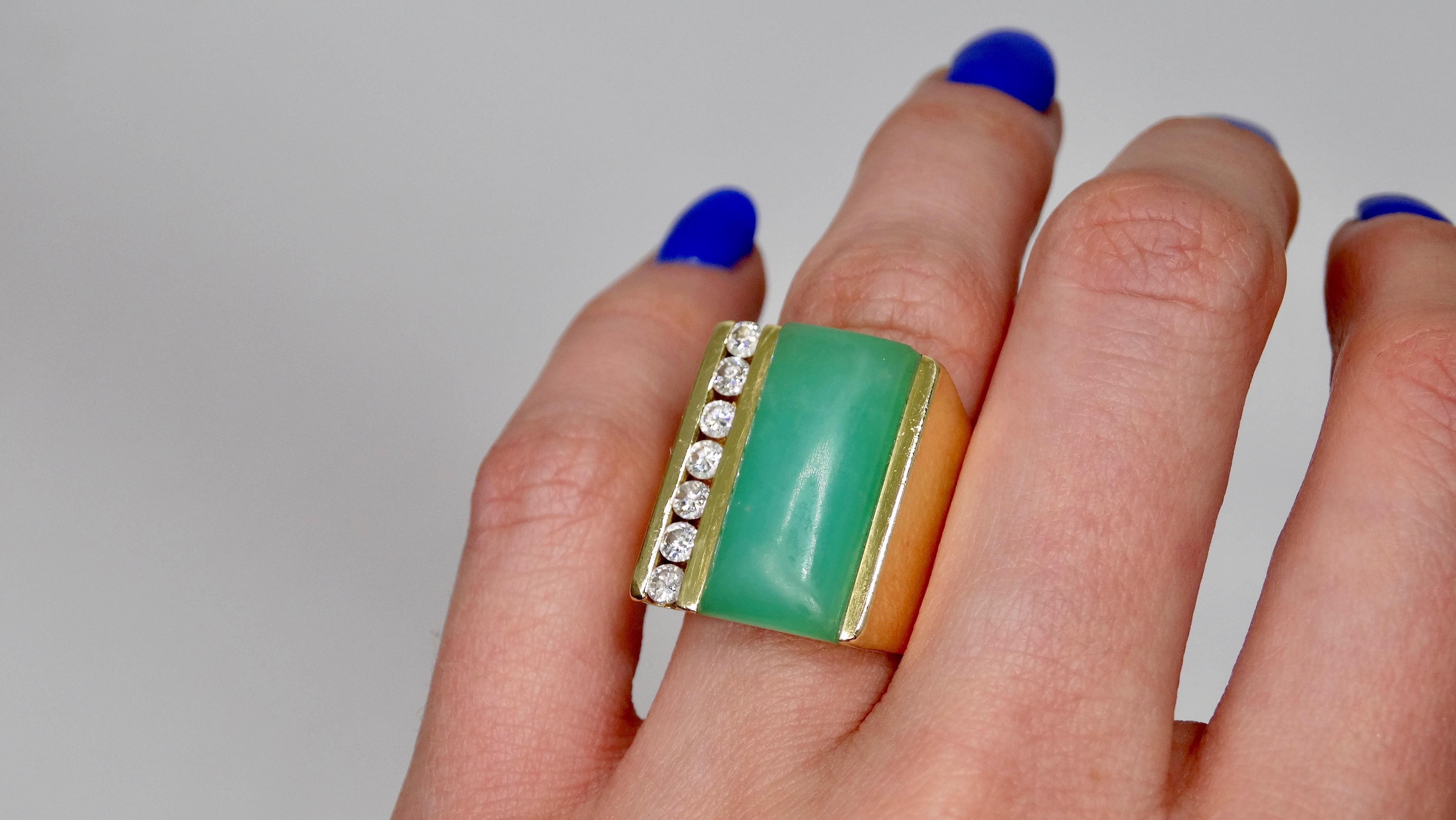 Elevate your look with this stunning cocktail ring! Circa mid-20th century, this 18k Gold ring features a thick band set with a beautifully polished Jade stone and single row of brilliant round cut Diamonds. Interior of band is stamped 18k Gold and