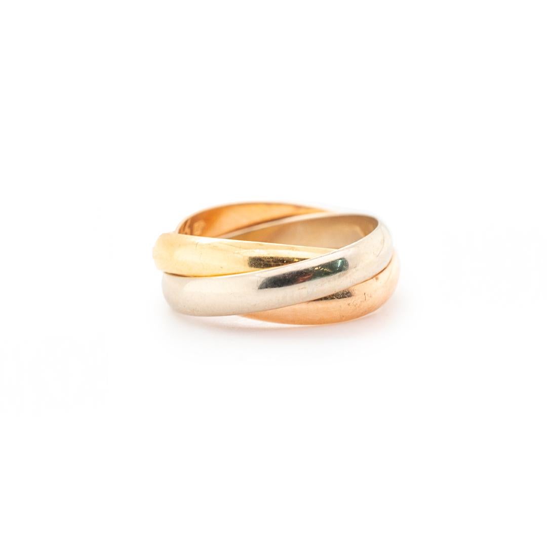 One ladies custom designed polished, 18K yellow gold, 18K white gold and 18K rose gold, rolling ring with a half round shank. The ring is a size 4 and is 0.84mm thick. The ring weighs a total of 5.50 grams. Engraved with 
