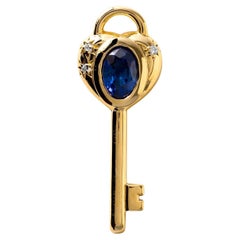 Ciondolo con chiave d'amore in oro 18K, zaffiro ovale e diamante