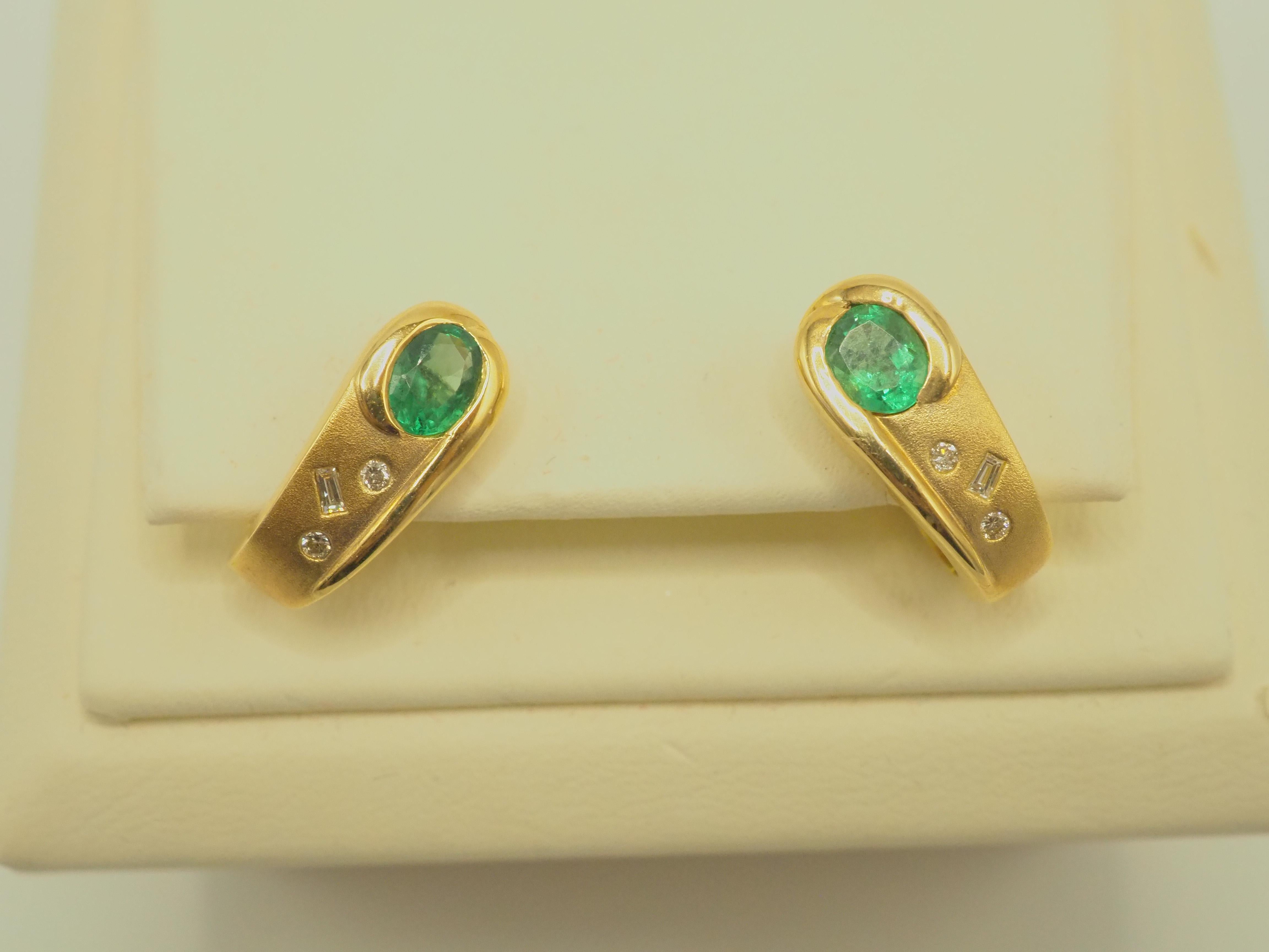 This piece is a fine and gorgeous oval vibrant green emerald and diamond unique earring. The oval emeralds have very nice bright green tone and saturation with good clarity. The six baguette and round diamonds are genuine with good color and