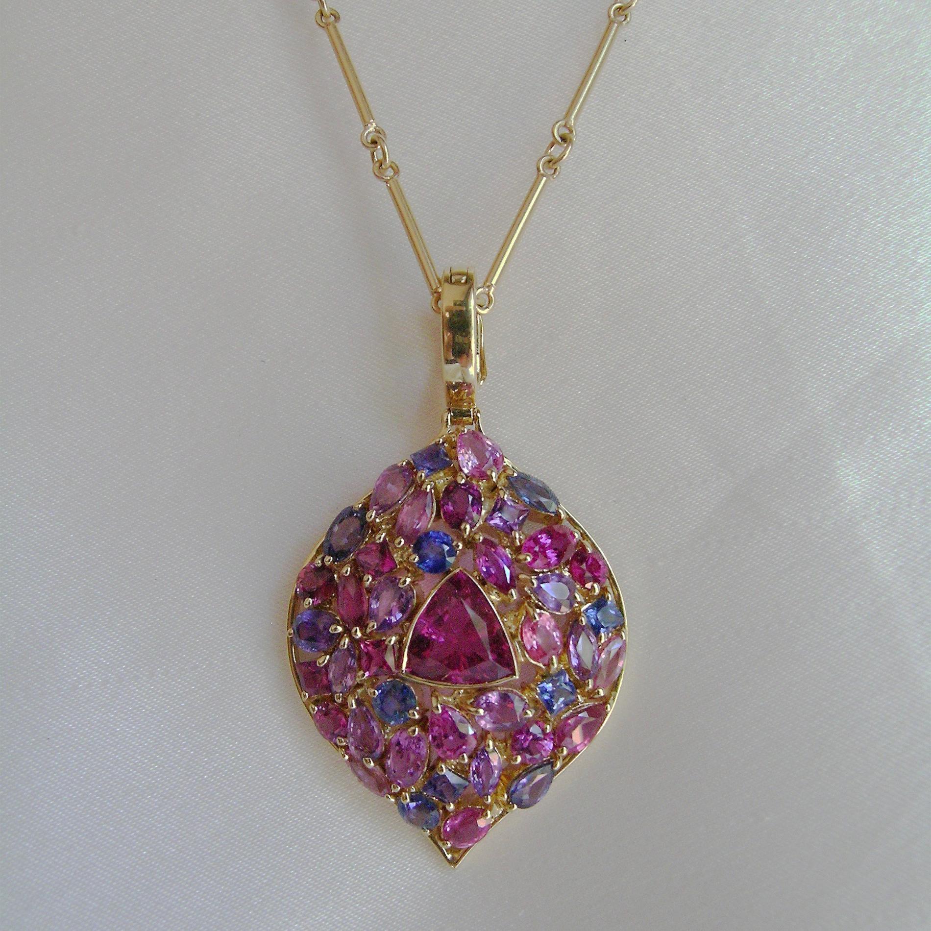 14 cts. of Rubelite, Sapphire and Tourmaline are set into 18k Gold for a very colorful and bold pendant.  If you love color then this is a great pendant for you.  The stone in the middle is the rubelite tourmaline, the deepest red of all the