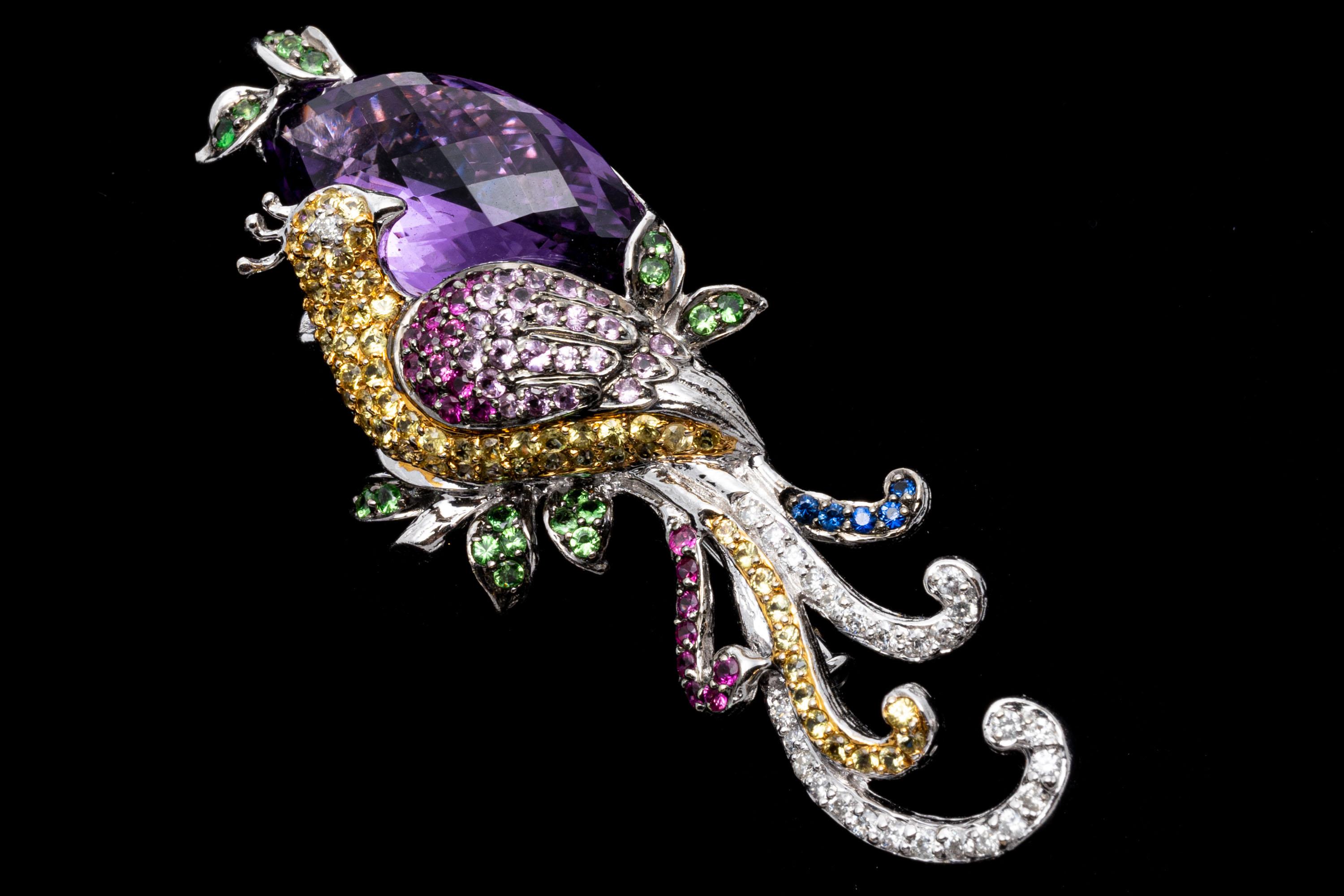 18k white gold brooch. This magnificent brooch is a bird of paradise motif, prong set with a chest of round faceted yellow sapphires that lead into the tail (approximately 1.98 TCW), wings of ombre dark to light pink sapphires that also lead into