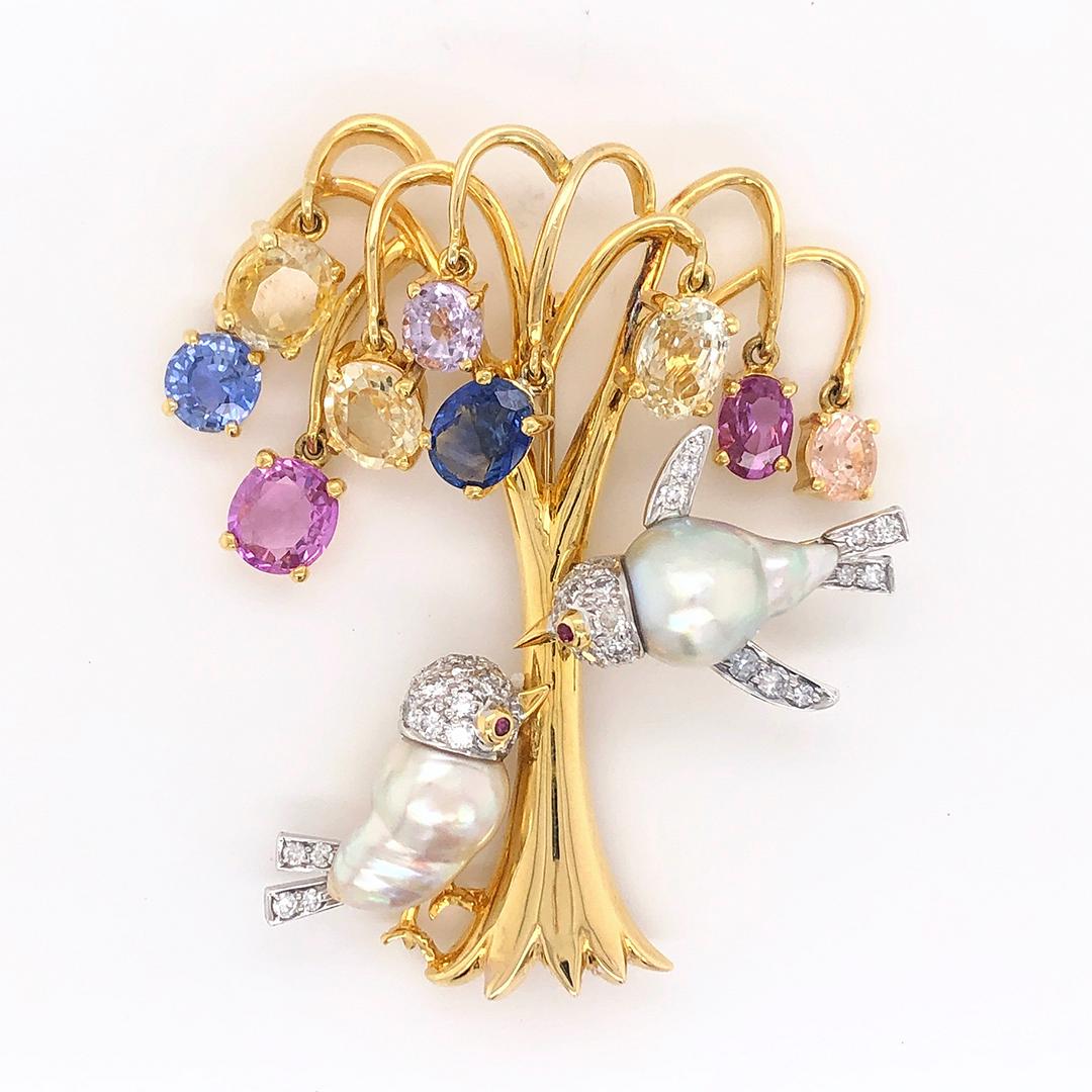 18k Gold Multi-Colored Sapphire Brooch with Pearls and Diamonds

This stunning brooch features a stunning array of sapphires totaling 12.61 carats, spanning across hues of blue, violet, yellow, pink, lavender, white, and orange that glisten like a