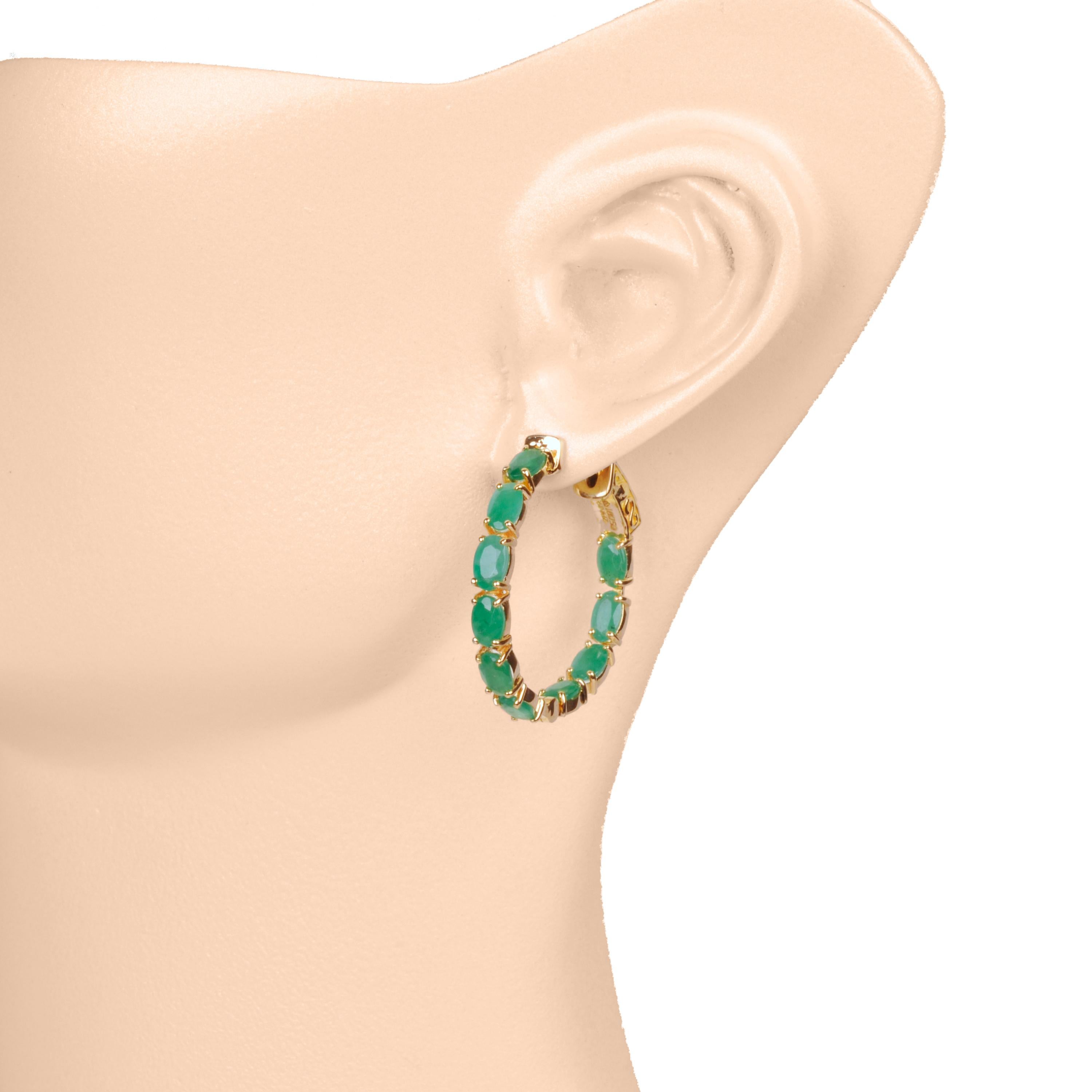 Elevate your elegance with our 18K Gold Brazilian Emerald 5x3 Oval Classic Hoop Earrings with an easy to use lock system. A true embodiment of luxury and grace, these earrings showcase the mesmerizing allure of lustrous emeralds in a uniquely