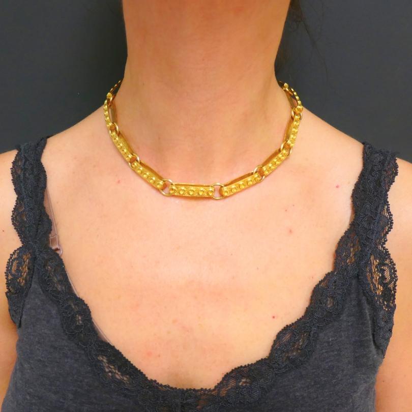 Vintage-Halskette aus 18 Karat Gold mit schweren Gliedern. u2028Die Glieder sind als abgerundete Schleifen gestaltet, die mit Gravuren strukturiert und mit glatten Goldringen verbunden sind. Sie verleiht der Halskette einen substanziellen, kühnen