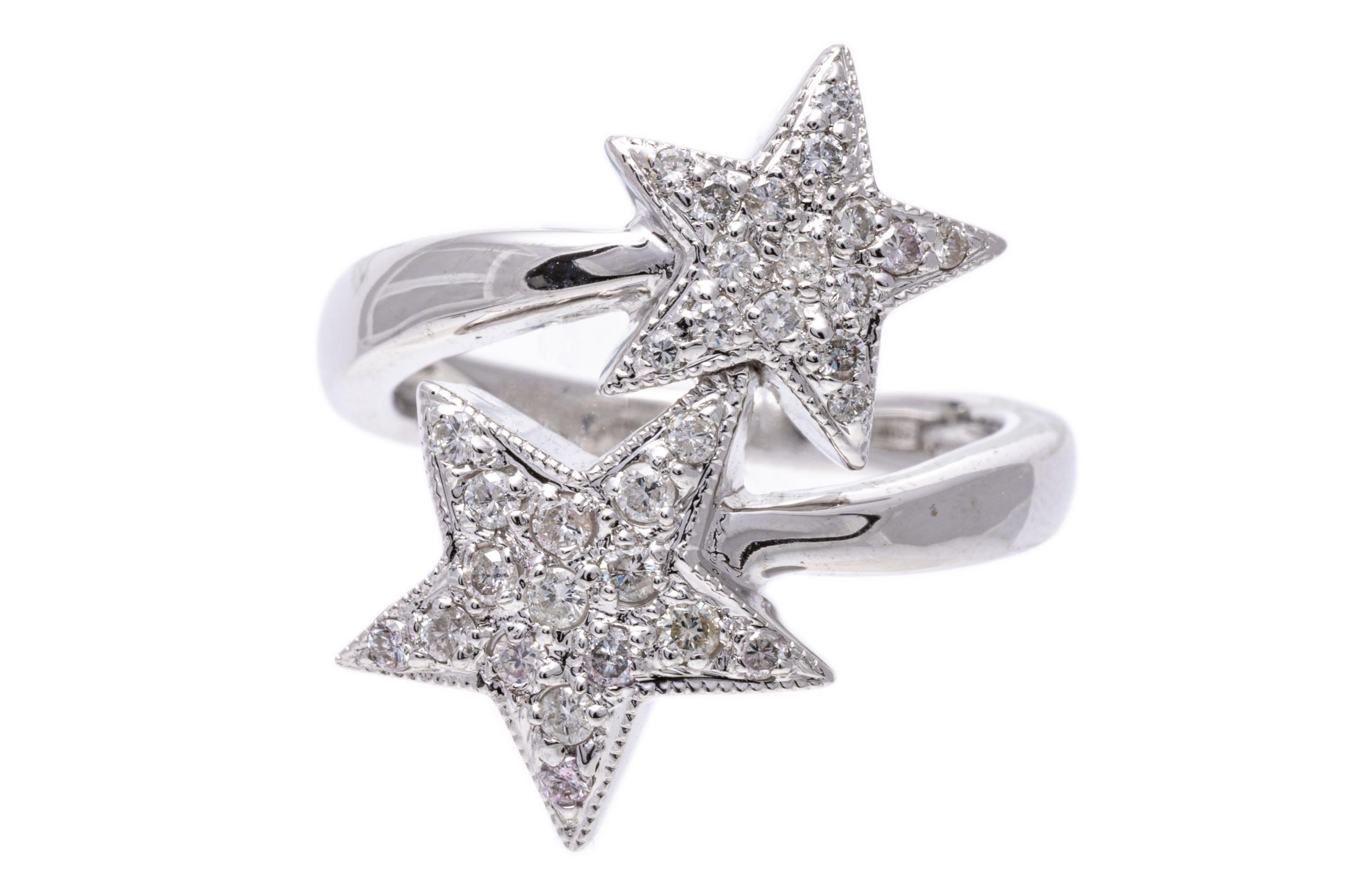 18k white gold ring. This playful ring is a bypass, crossover style, adorned with two complementary offset stars, decorated with round faceted diamonds, approximately 0.29 TCW, pave set and finished with a high polished shank.
Marks: 750
Dimensions: