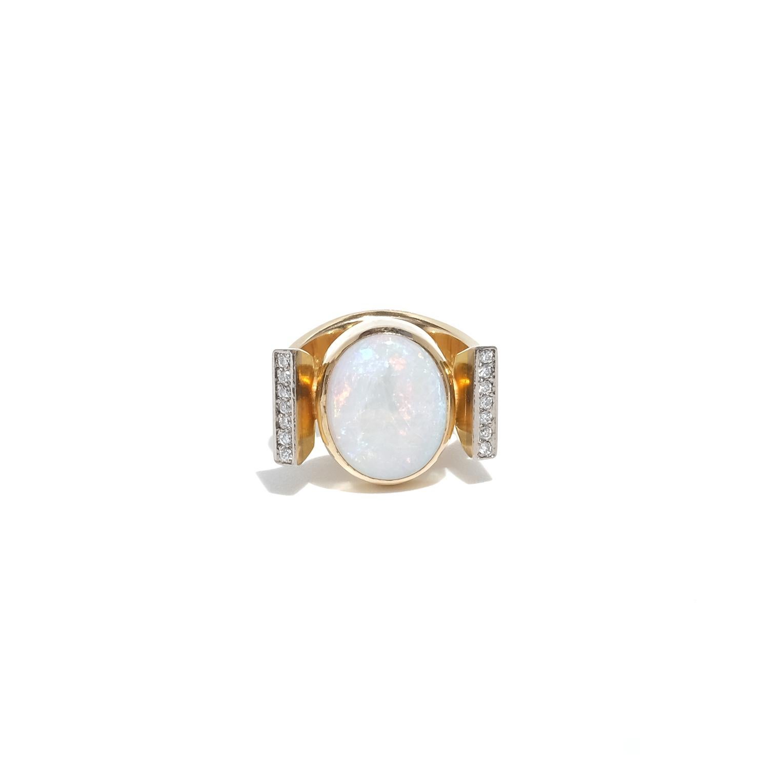 Questo anello in oro a 18 carati presenta un sorprendente opale ovale incastonato in una fascia spessa e scolpita che è larga alla base, si restringe salendo e poi si allarga di nuovo quando le braccia avvolgono elegantemente l'opale. L'opale mostra