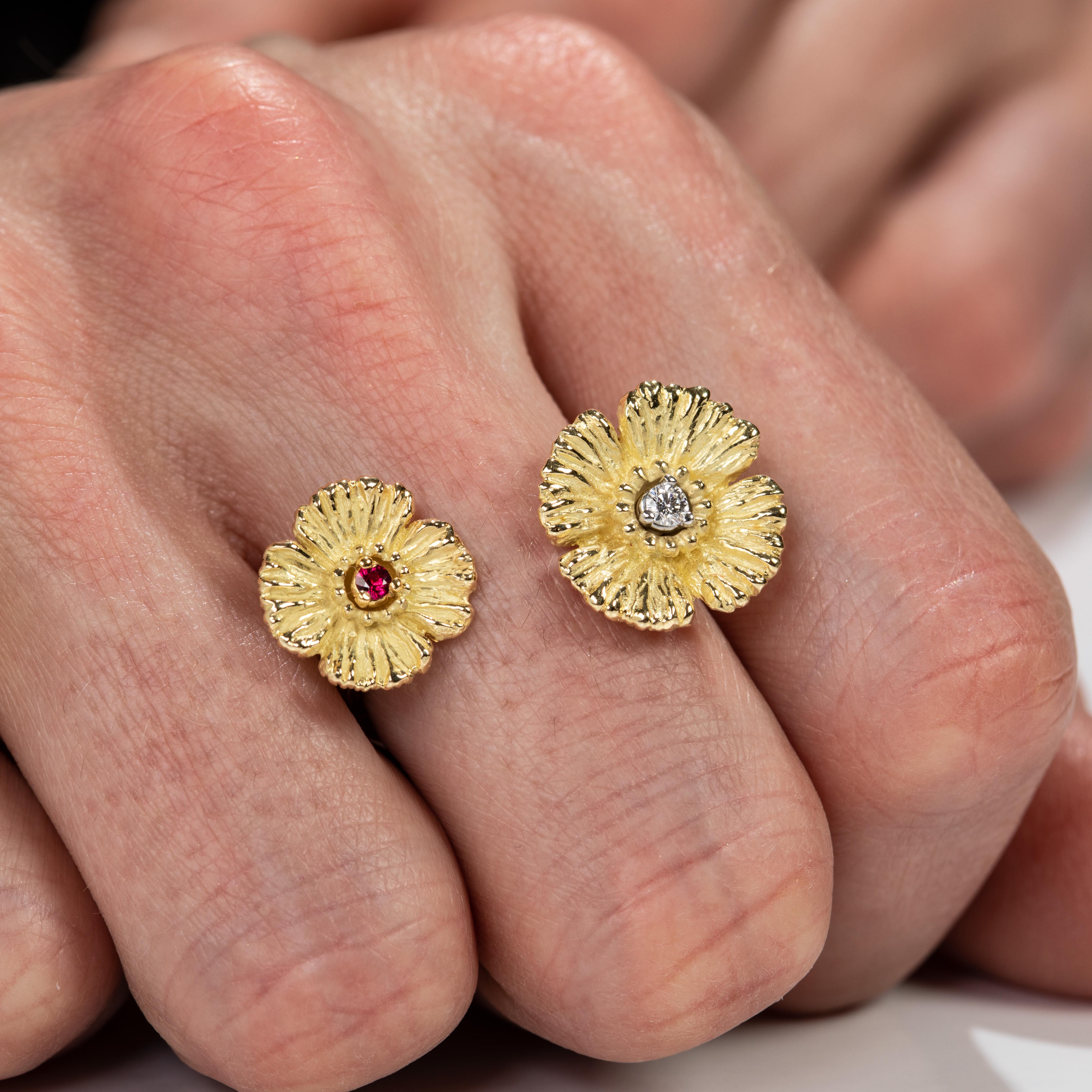 Part of the Gloria Bass Design Poppy collection, this asymmetrical open style ring in 18k yellow gold features 2 poppies of different sizes , containing a diamond in one and a ruby in the other, for an added dose of colour and richness to an