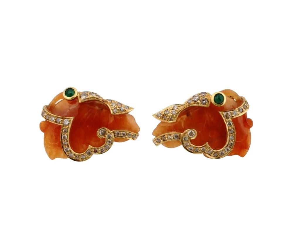 An 18K Yellow Gold figural cufflinks. The cufflinks are made of hand carved and engraved orange Jade. The ware is encrusted with Diamonds and Emerald stones. Marked with a standard Gold hallmark, an EG, Eterna Gold, mark. Weight 15.5 grams. Vintage