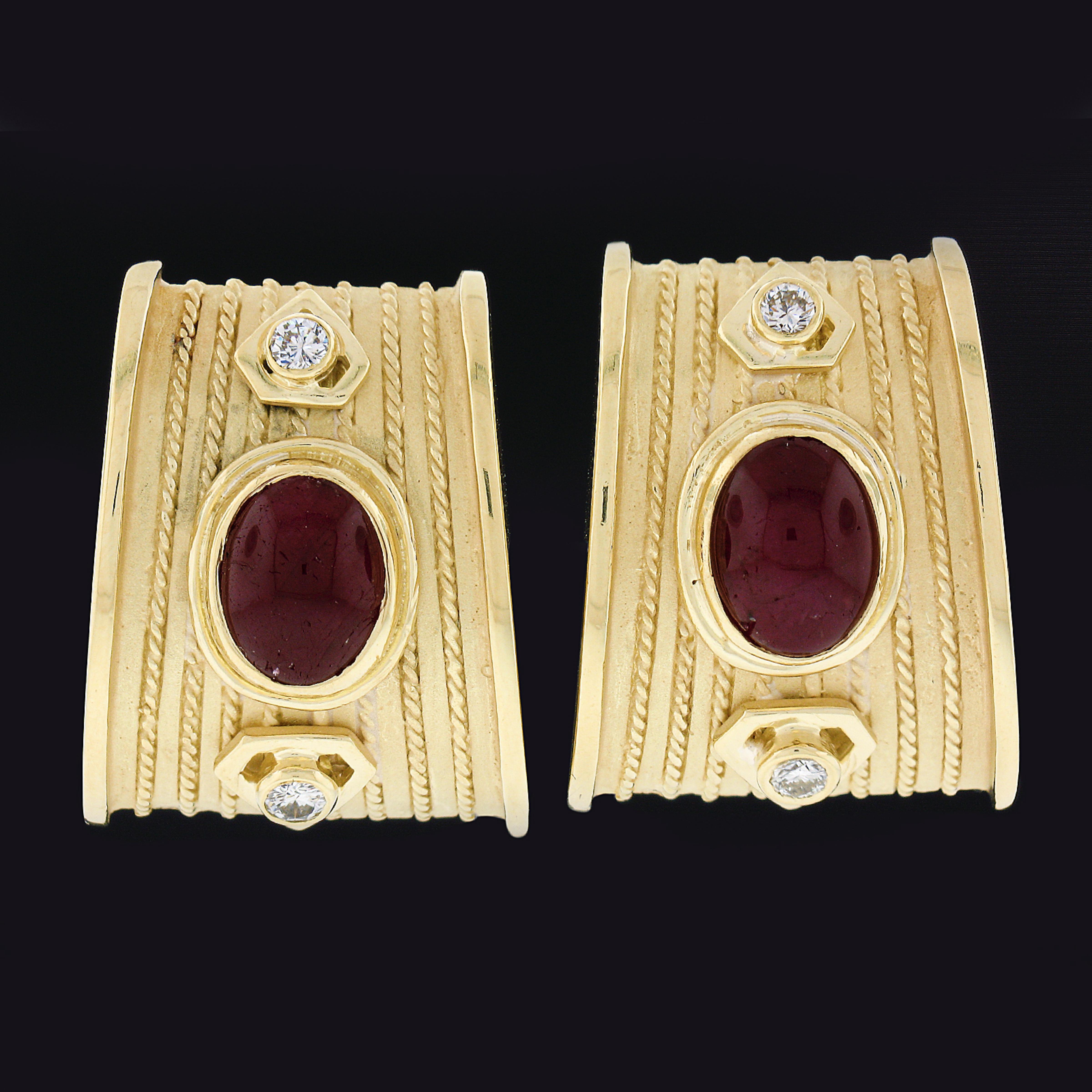 This gorgeous and very well made pair of earrings is crafted in solid 18k yellow gold and feature an absolutely outstanding design set with fine quality rubies and diamonds. These earrings carry oval cabochon cut rubies in which are neatly bezel set