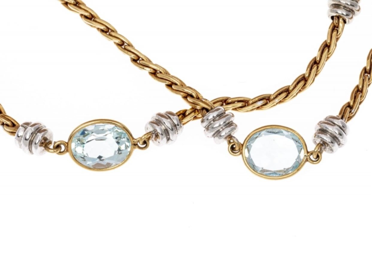 This gorgeous necklace contains ten beautiful oval faceted, pale light blue color aquamarine stones, approximately 25.8 TCW and bezel set. Alternating with the aquamarines are white gold, ribbed stations, and a rounded yellow gold braided chain. The