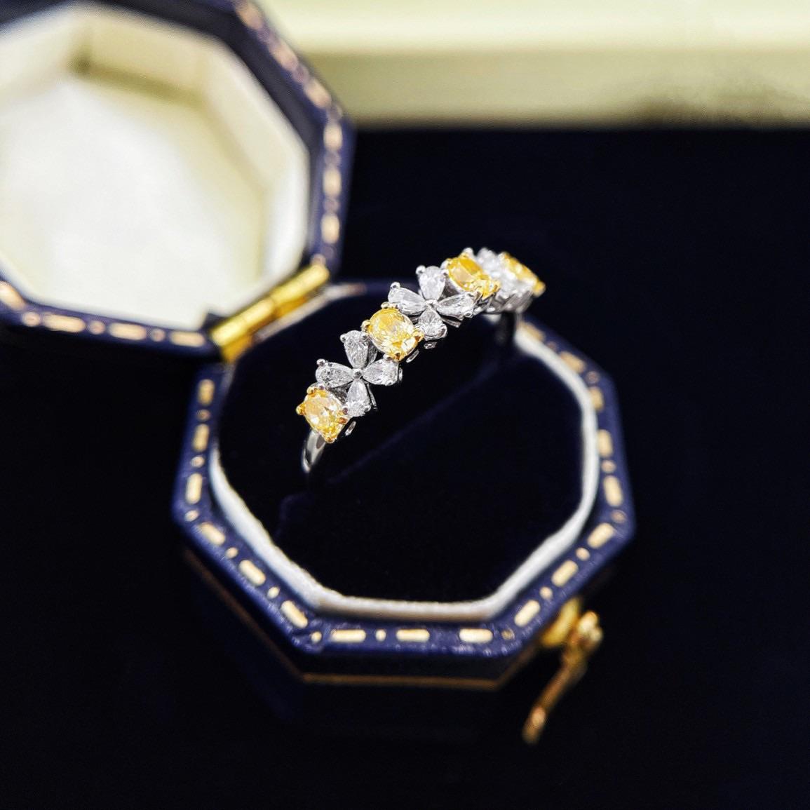 Célébrez l'élégance et la beauté rare avec cette bague à quatre feuilles en or jaune 18 carats, qui présente un superbe arrangement de diamants jaunes naturels. Au cœur du design se trouve un diamant jaune de taille ovale pesant 0,32ct, complété par