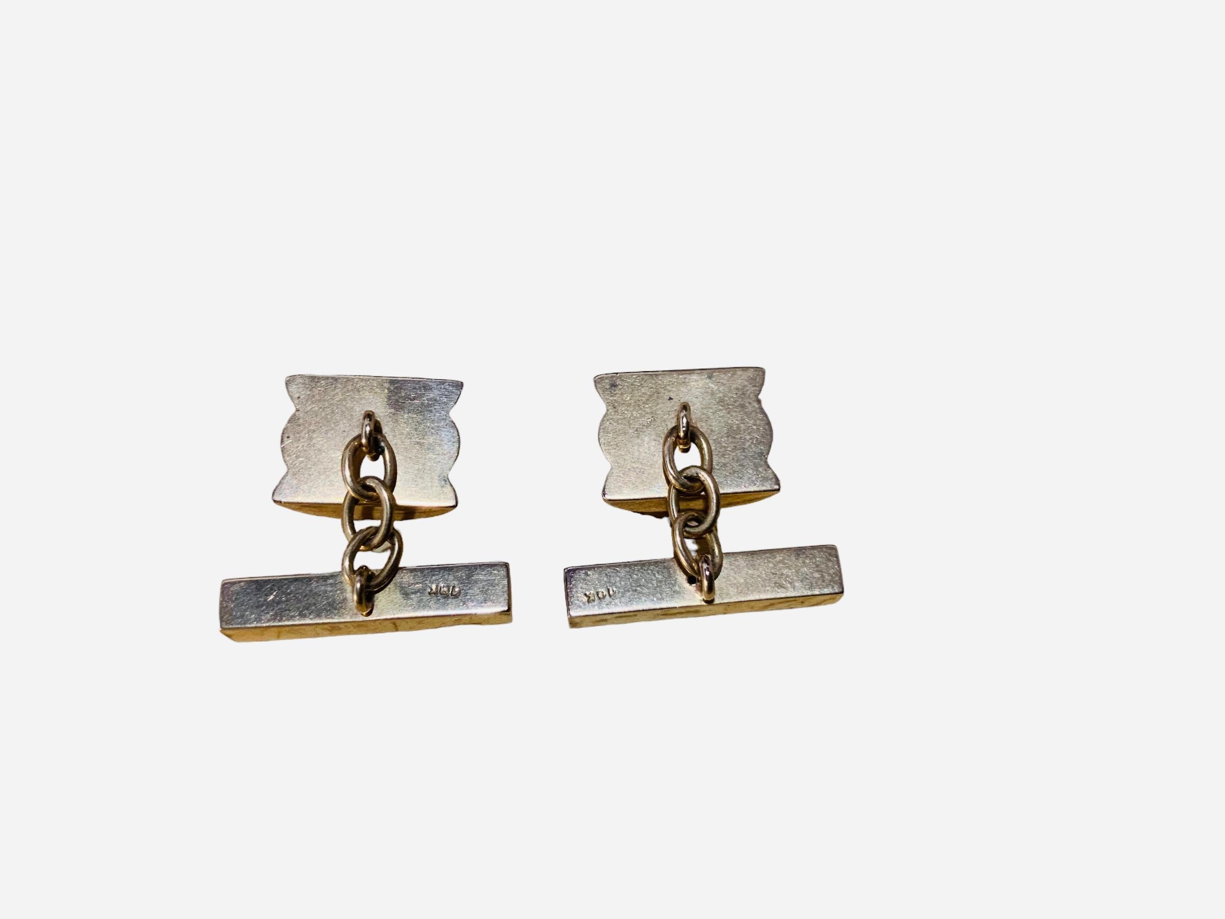 This is a pair of 18K yellow gold barrel shaped chain link cufflinks. They are hallmarked 18K in the gold bar joined by the chain to the barrel. The measurements of the barrel is approximately 0.3 x 0.5 inches.
