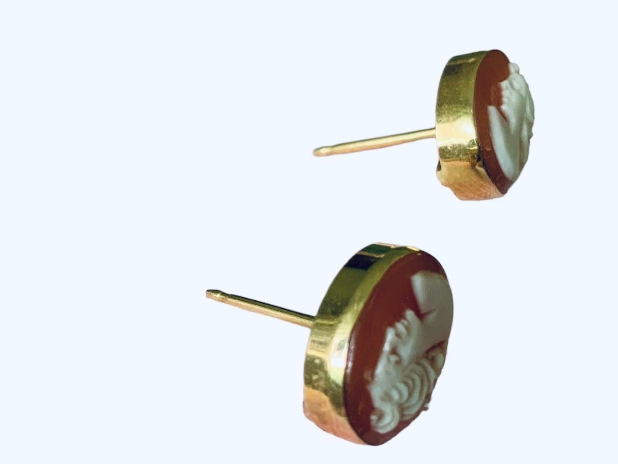 This is an 18K Gold Pair of Cameo Earrings. It depicts a pleasing vintage and hand carved shell cameo with a lady profile mounted in 18K yellow gold pressure punch back. They are hallmarked 750 in the back.