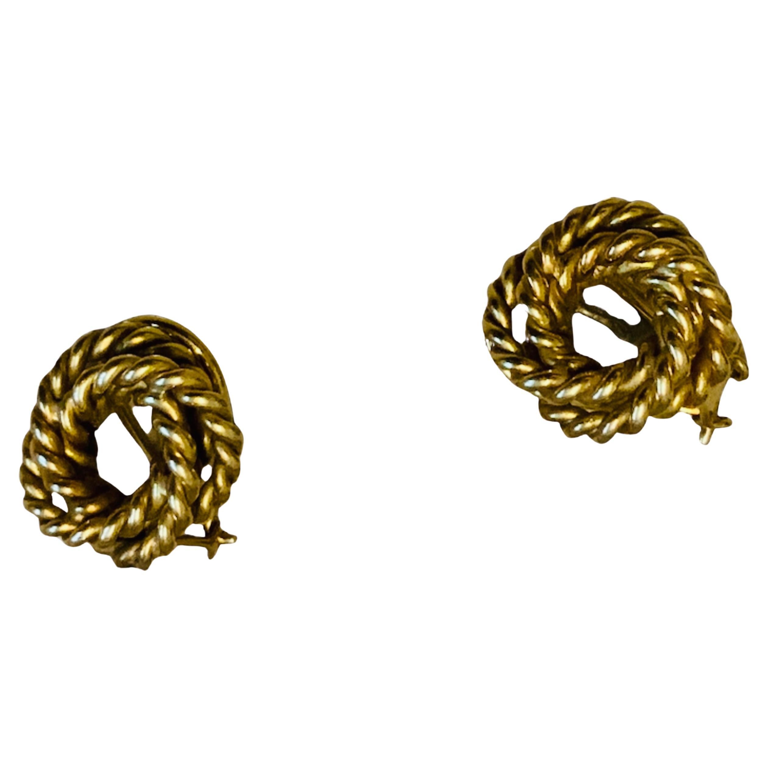 This is an 18K Gold Pair of Clip Earrings. It depicts a gold rope enrolled and twisted few times to form a circle. Both of them are hallmarked 18K in the back.