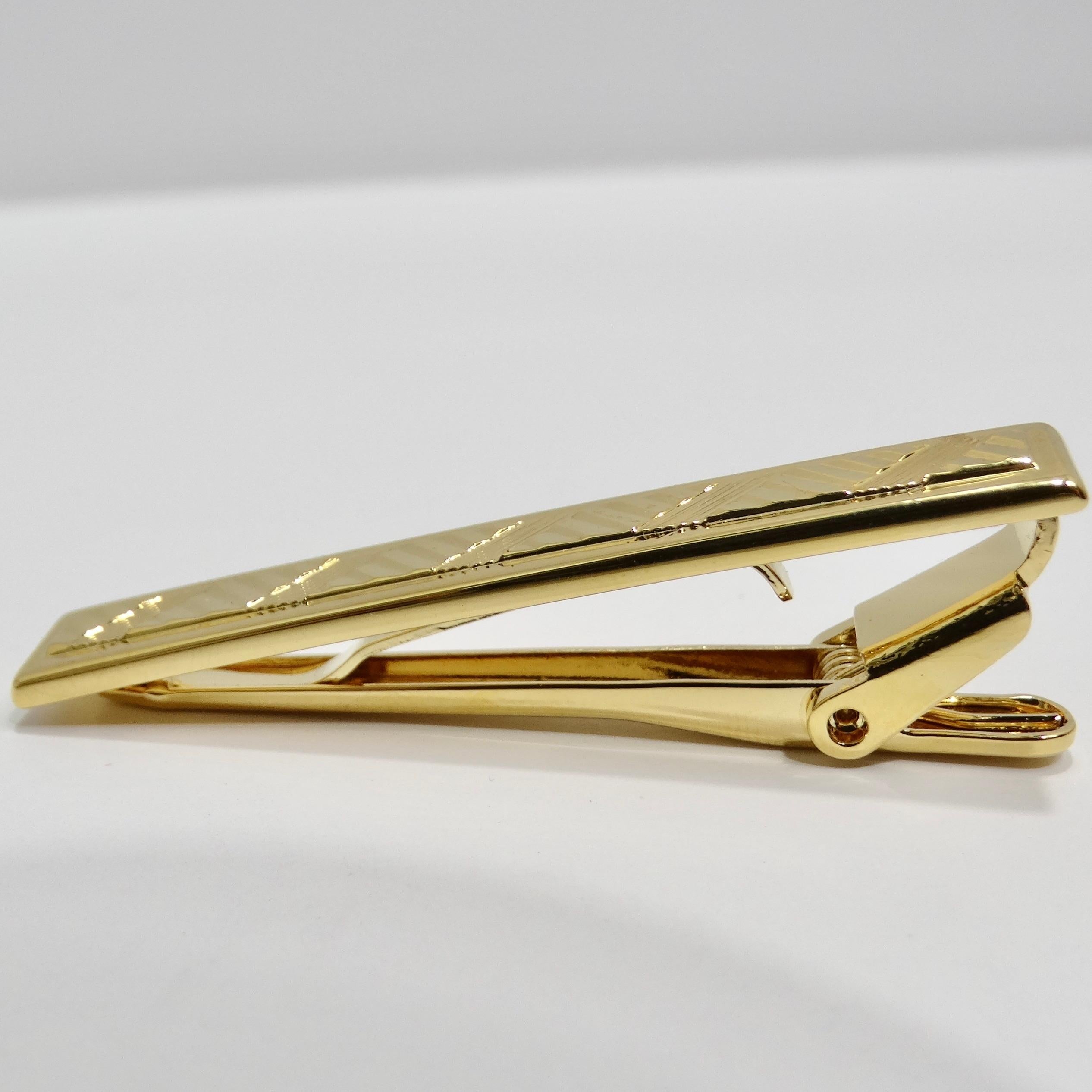 Introducing the 18K Gold Plated 1980d Tie Clip, a classic vintage piece that adds a touch of luxury and sophistication to any formal look. This tie clip is crafted with 18k yellow gold plating, offering a warm and lustrous finish that exudes