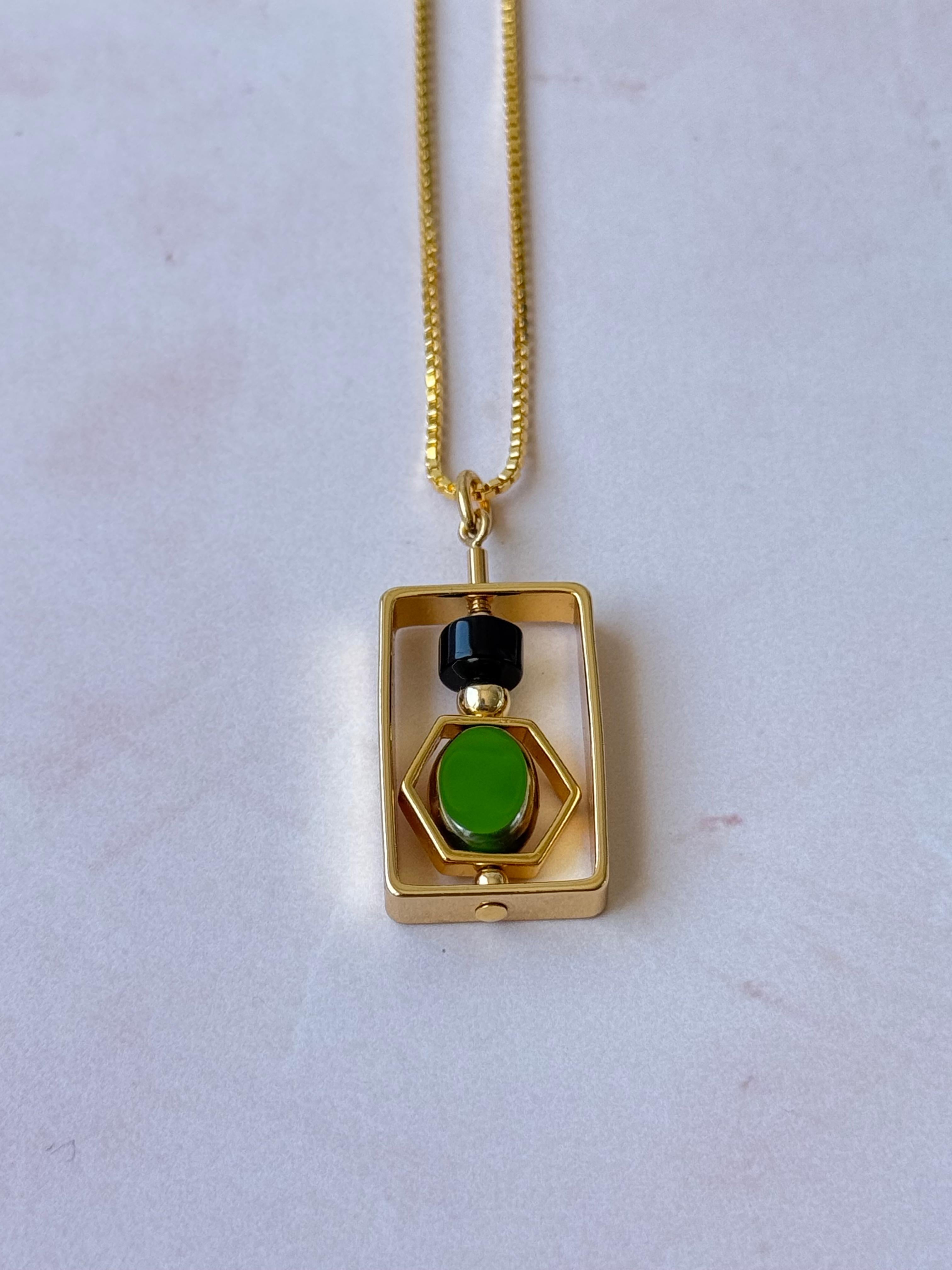 La modella indossa una catena da 18 pollici. Il ciondolo è composto da una gemma di onice nera e da perle di vetro tedesco vintage nuove di zecca, incorniciate da oro 24 carati. La maggior parte delle perline utilizzate nella collezione sono state