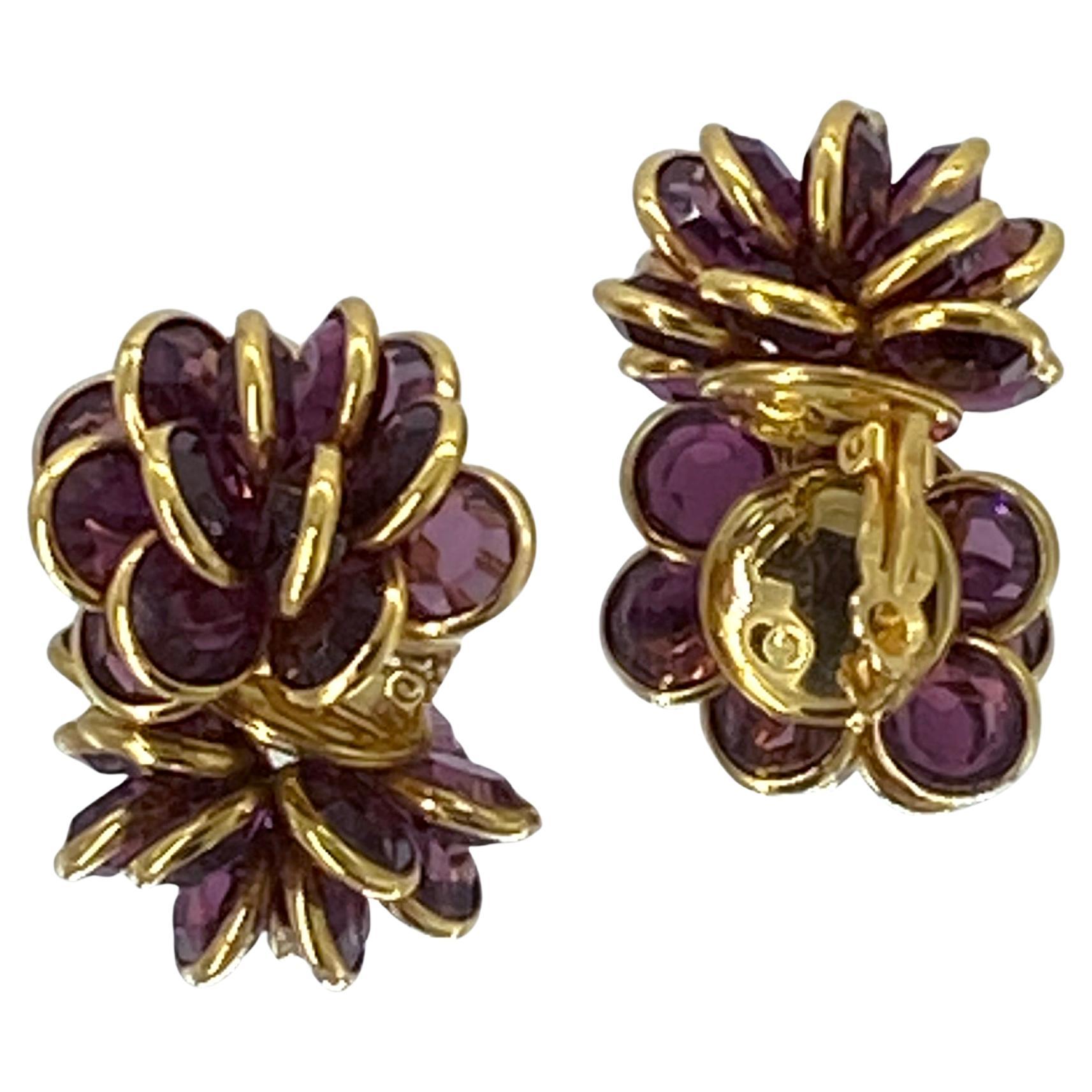 Si tratta di un paio di orecchini a grappolo in cristallo viola Swarovski. Sono realizzati con una ricca placca d'oro 18 carati. Ognuno di essi contiene quindici pietre di cristallo sfaccettato viola da 10 mm incastonate a formare un grande