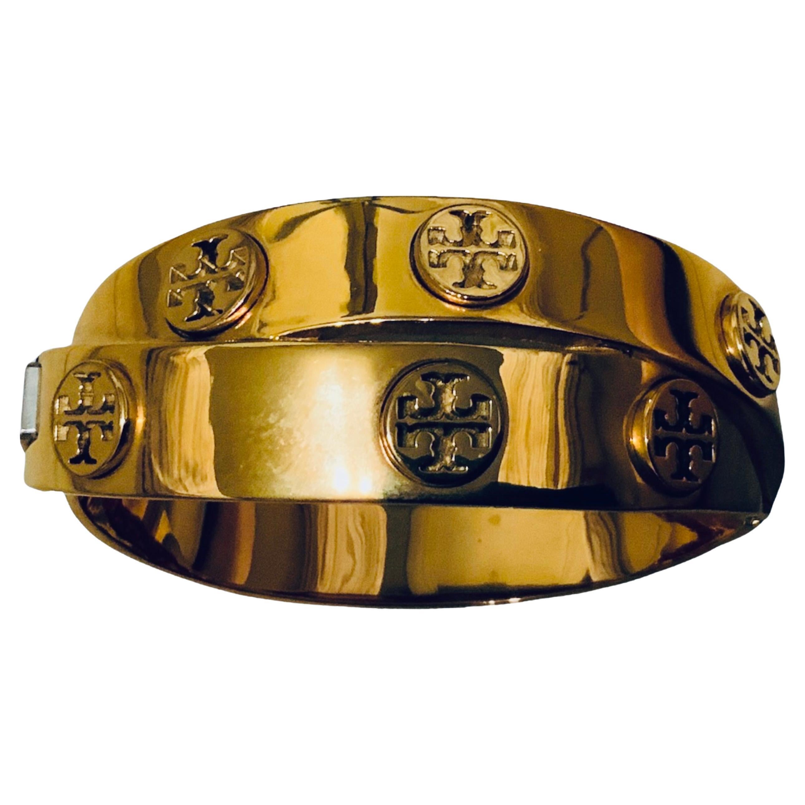 This is a Tory Burch 18K Rose Gold plated Hinged Bangle. It depicts a Tory Burch logo double wrap hinged bangle.