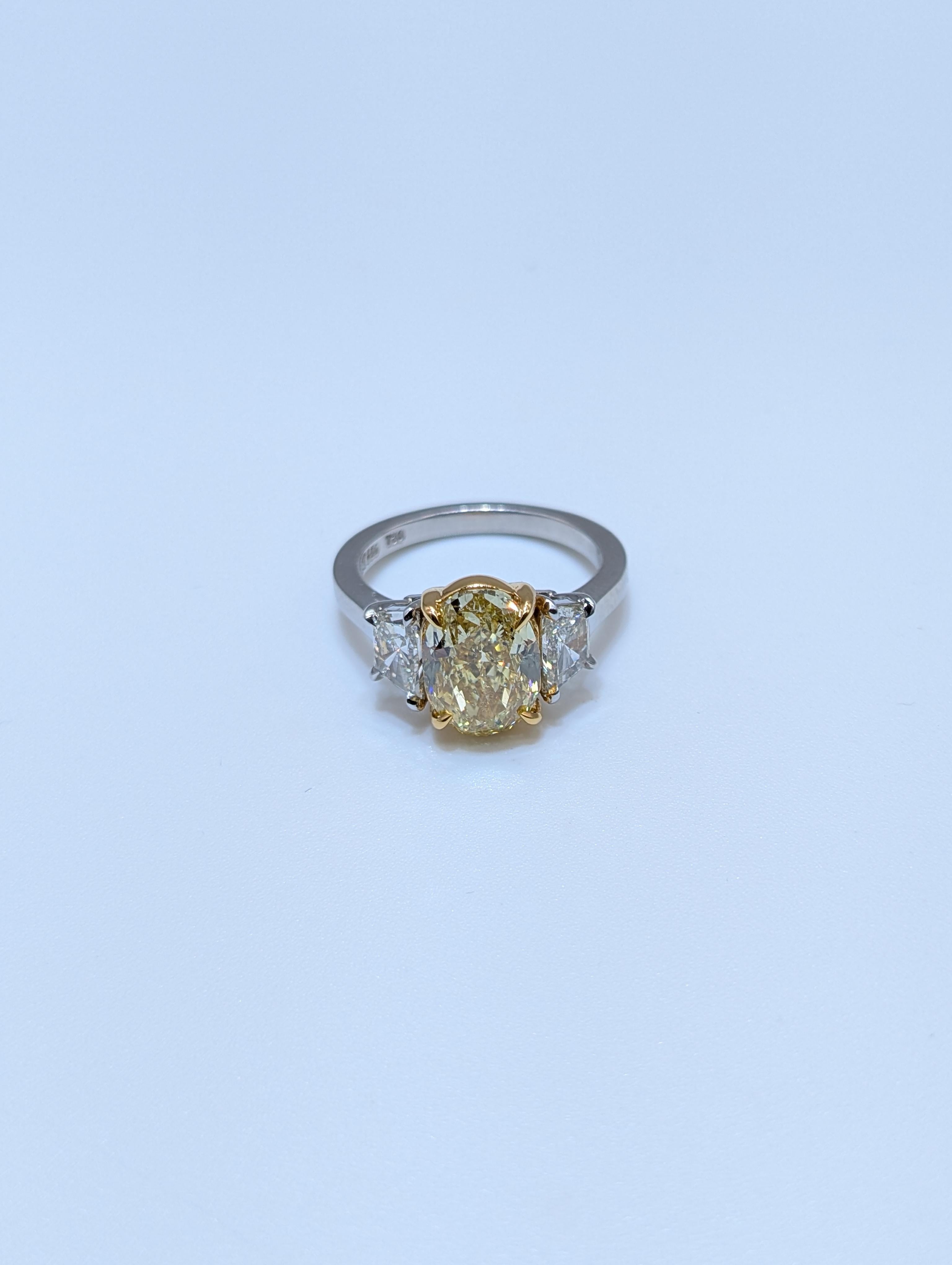 Cette étonnante bague en or jaune 18 carats et platine certifiée GIA et ornée d'un diamant naturel de couleur jaune fantaisie présente un captivant diamant de taille ovale de 4,01 carats de couleur jaune fantaisie, d'une brillance et d'une rareté