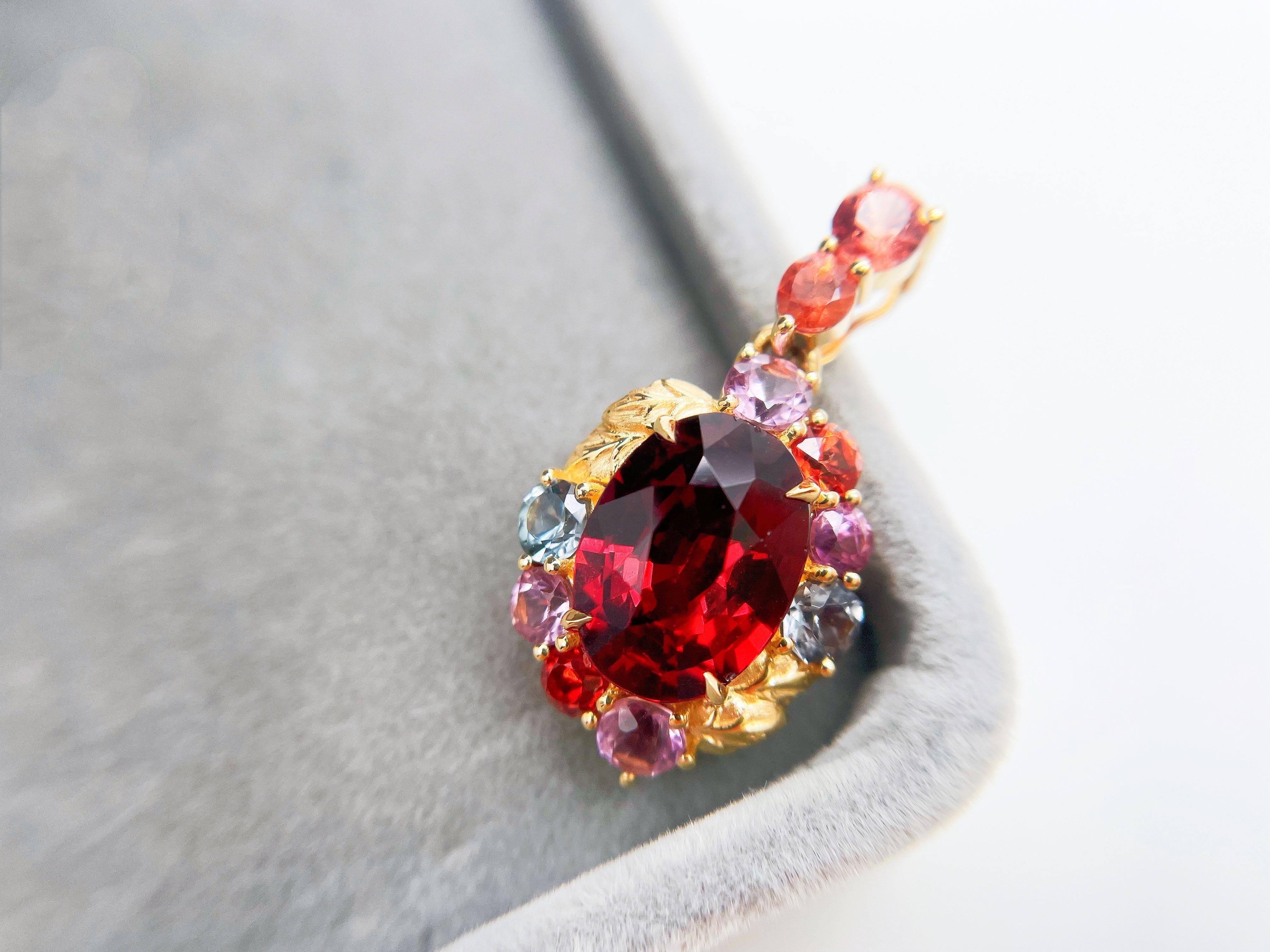 Discover the captivating beauty of this one-of-a-kind pendant, a true masterpiece of custom jewellery design. Centred around a vibrant red garnet, the 18K yellow gold setting features intricate leafy shapes that elegantly embrace the gemstone.