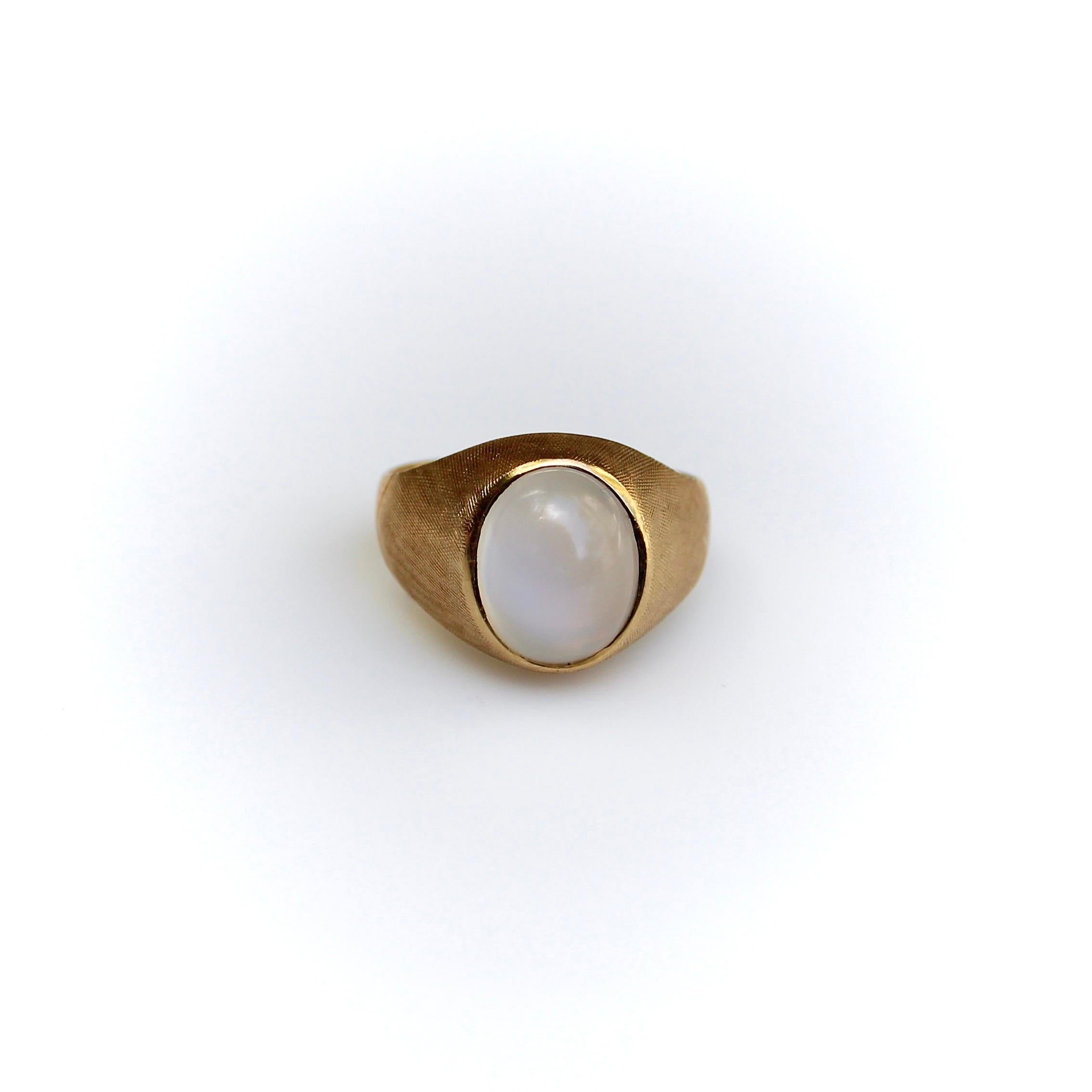 This retro Tiffany & Co. ring features a moonstone bezel set into an 18k gold ring with a beautiful Florentine finish. The ring has a high profile; the deep cabochon goes from milky white to a blue glow, with a cat’s eye that moves in the light. The